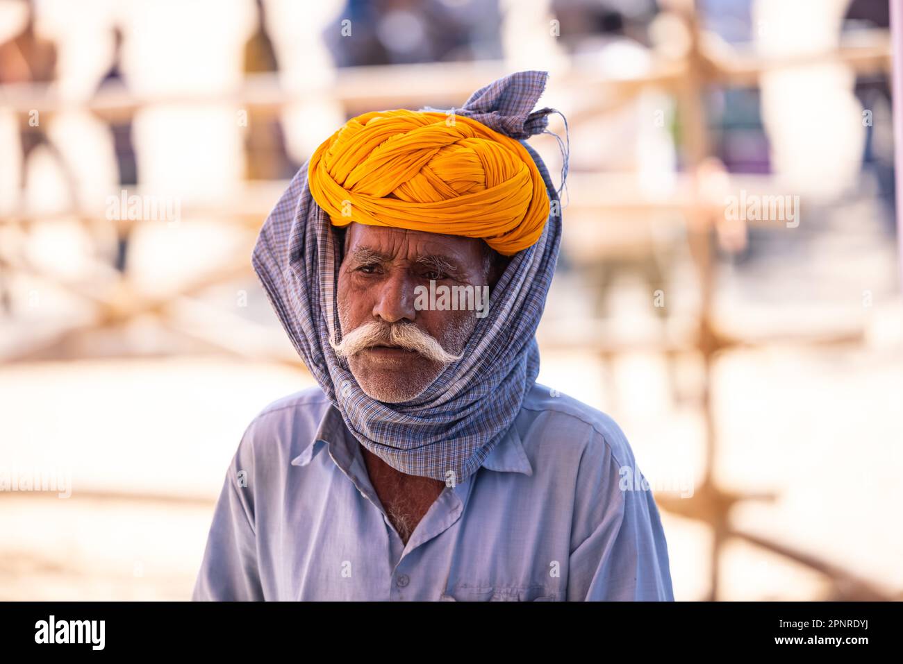 Pushkar, India - ottobre 2022: Fiera di Pushkar, Ritratto di un vecchio maschio rajasthani con abiti tradizionali bianchi e turbano colorato al terreno fieristico di pushkar Foto Stock