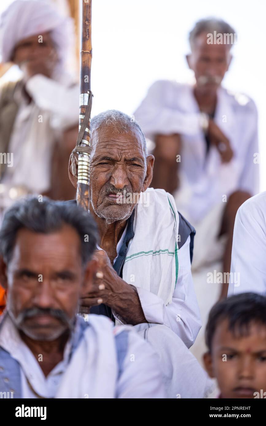 Pushkar, India - ottobre 2022: Fiera di Pushkar, Ritratto di un vecchio maschio rajasthani con abiti tradizionali bianchi e turbano colorato al terreno fieristico di pushkar Foto Stock