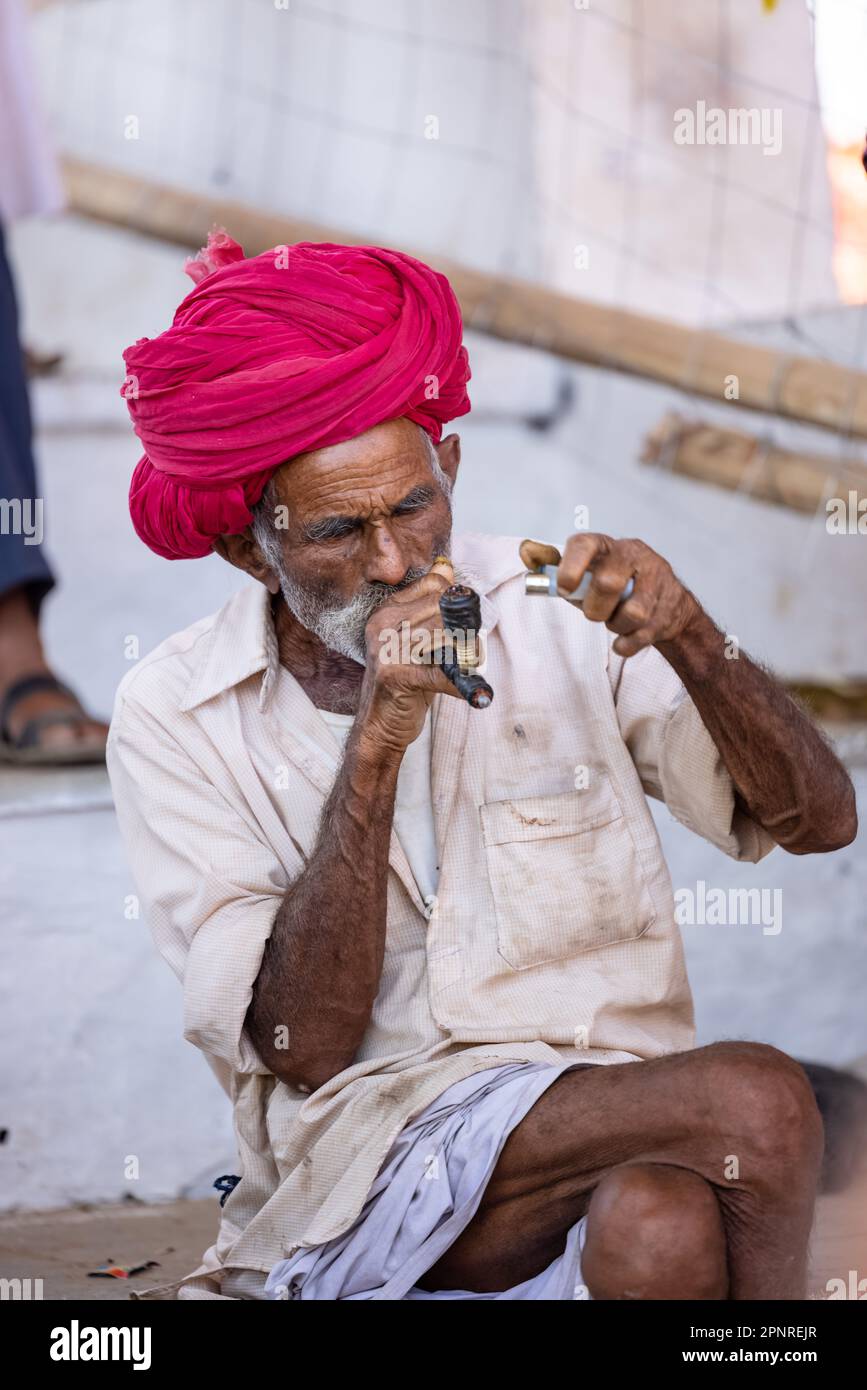Pushkar, India - ottobre 2022: Fiera di Pushkar, Ritratto di un vecchio maschio rajasthani con abiti tradizionali bianchi e turbano colorato al terreno fieristico di pushkar Foto Stock