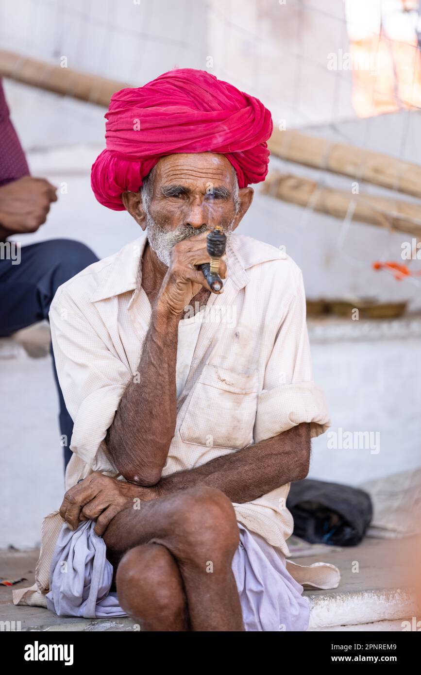 Pushkar, India - ottobre 2022: Fiera di Pushkar, Ritratto di un vecchio maschio rajasthani con abiti tradizionali bianchi e turbano colorato al terreno fieristico di pushkar Foto Stock