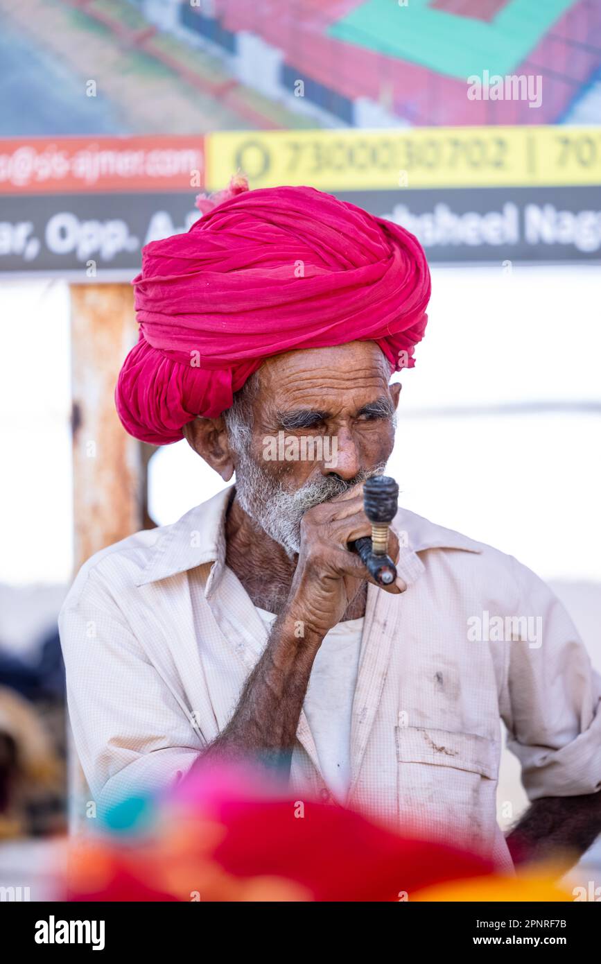 Pushkar, India - ottobre 2022: Fiera di Pushkar, Ritratto di un vecchio maschio rajasthani con abiti tradizionali bianchi e turbano colorato al terreno fieristico di pushkar Foto Stock