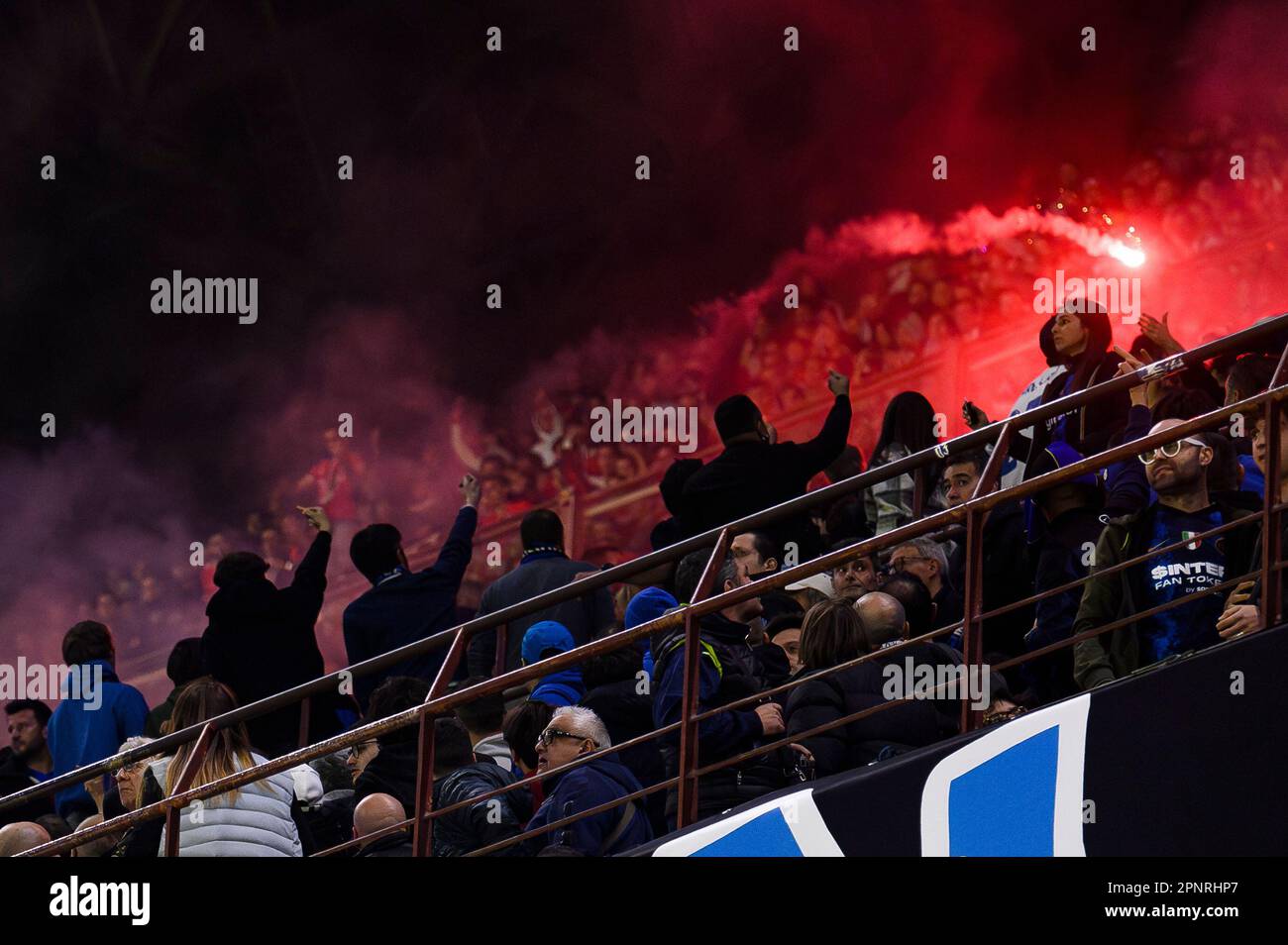 Milano, Italia. 20 aprile 2023. Un flare viene lanciato dal terzo livello in cui i tifosi Benfica si trovano al secondo livello tra i tifosi del FC Internazionale durante la partita di calcio di seconda tappa della UEFA Champions League tra FC Internazionale e SL Benfica. Credit: Nicolò campo/Alamy Live News Foto Stock