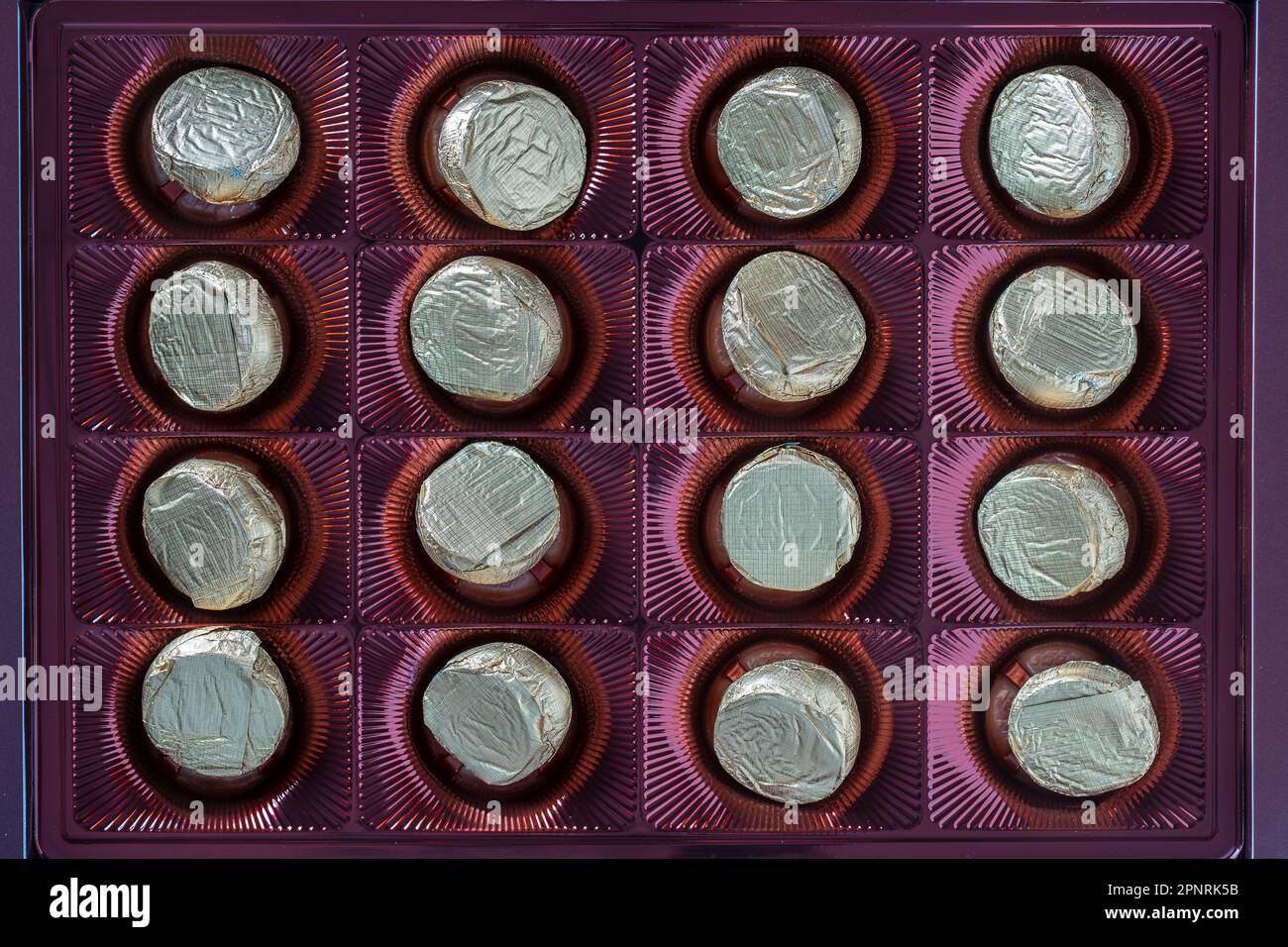 Confezioni di caramelle al cioccolato di foglio per sfondo. Assortimento di caramelle al cioccolato nella scatola, vista dall'alto, primo piano Foto Stock
