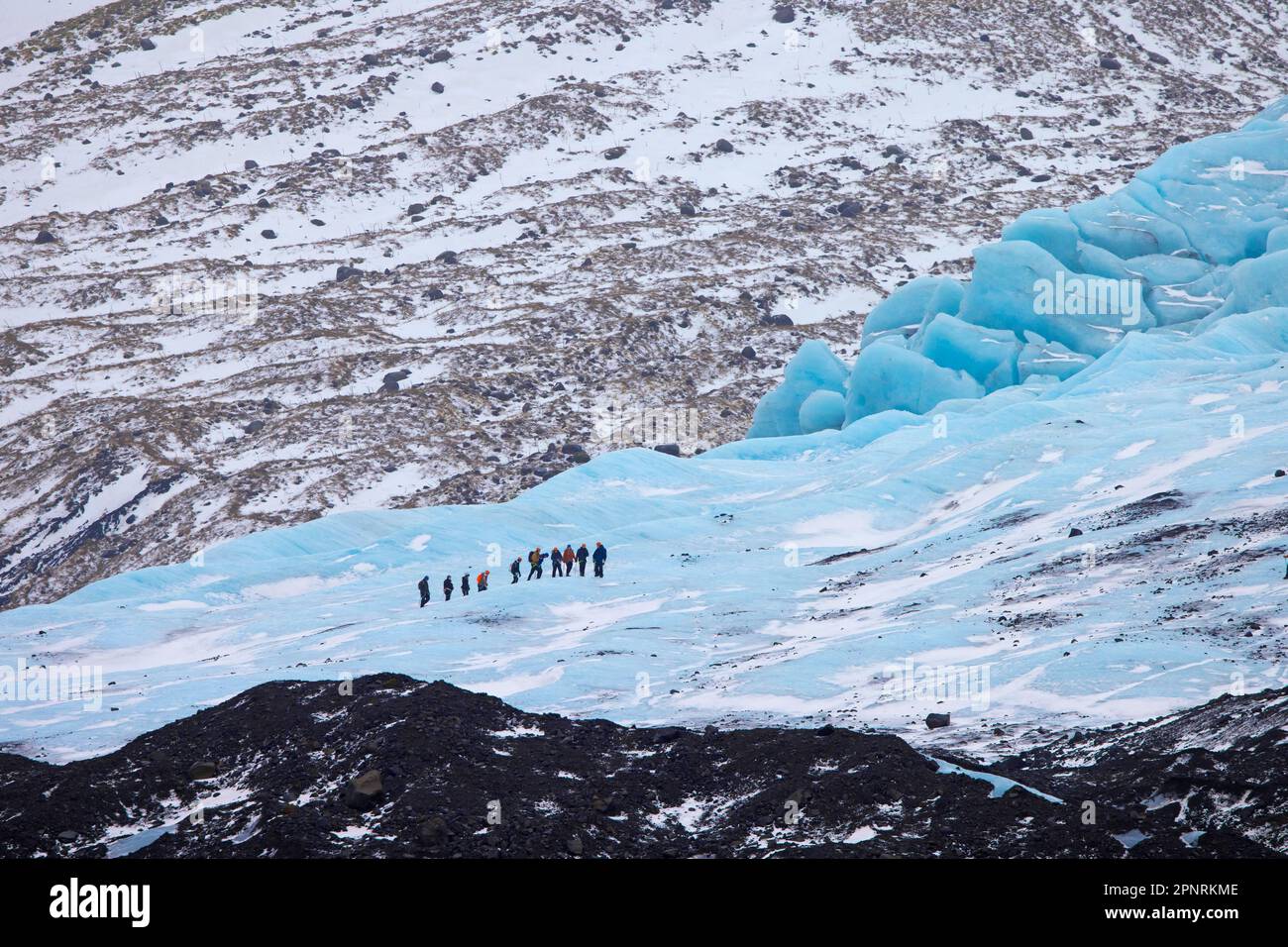 Turisti con guida visitare il ghiacciaio Falljökull / Falljoekull in inverno in Austurland, parte di Vatnajökull, il più grande cappello di ghiaccio in Islanda Foto Stock