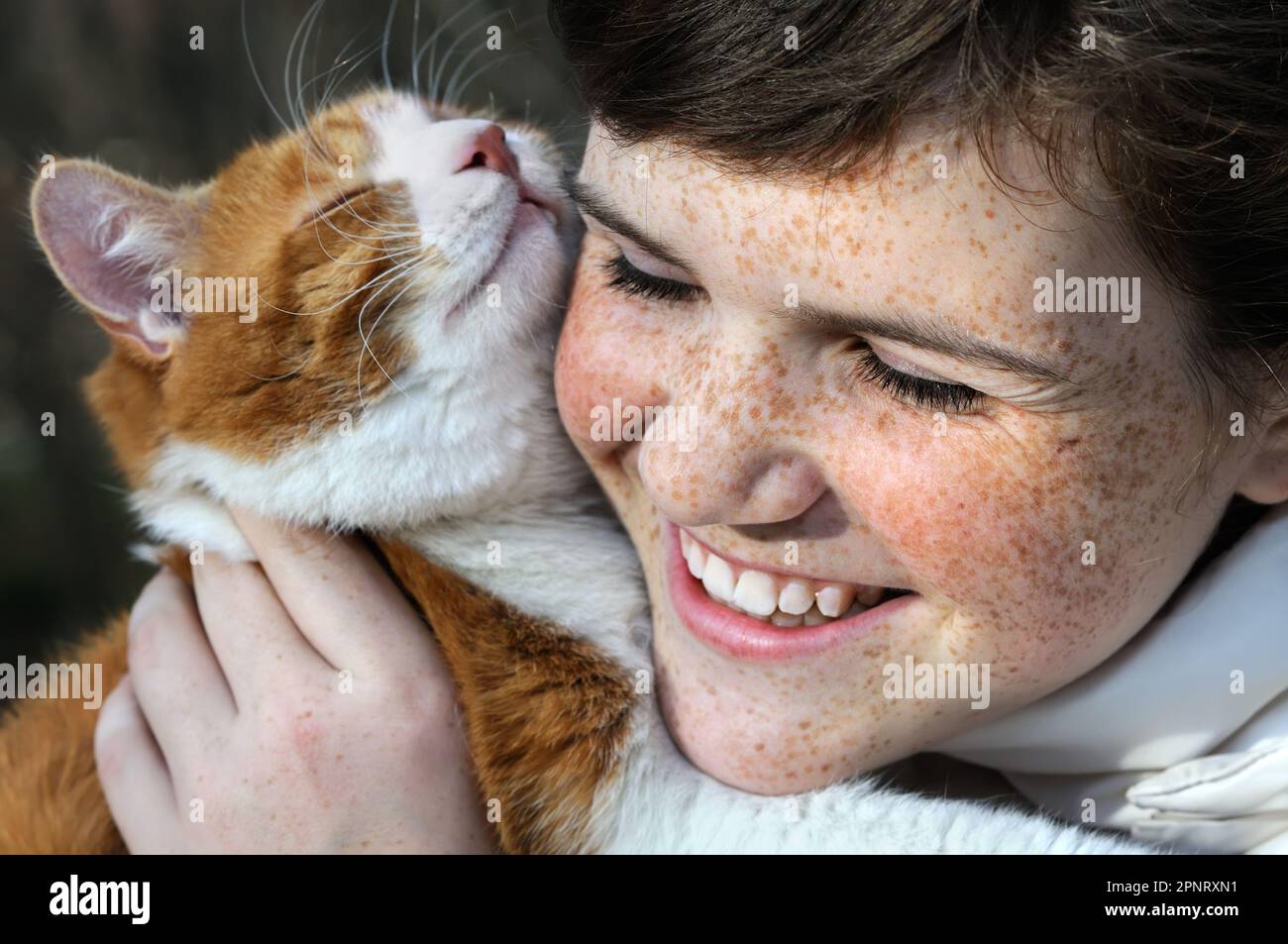 primo piano ritratto di felice ragazza e gatto rosso all'aperto Foto Stock