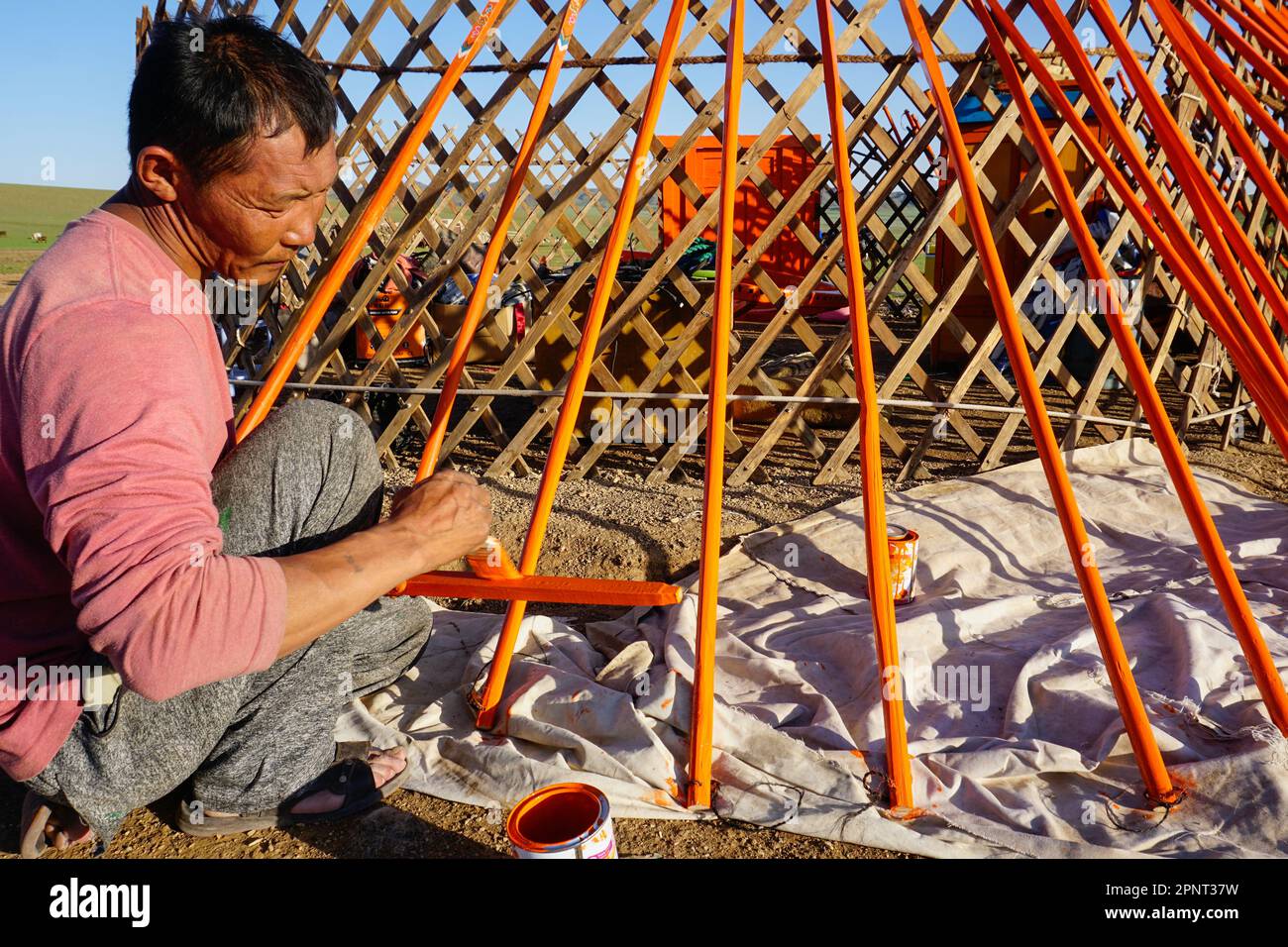 Batbayar Yondon, un pastore, dipinge la sua mangiatoia, o yurt, nella campagna a nord di Bayandalai, provincia di Umnugovi, Mongolia il 29 luglio 2021. I gers mongoli sono progettati per essere leggeri e durevoli, il che li rende adatti per uno stile di vita nomade. (Uranchimeg Tsoghuu/Global Press Journal) Foto Stock