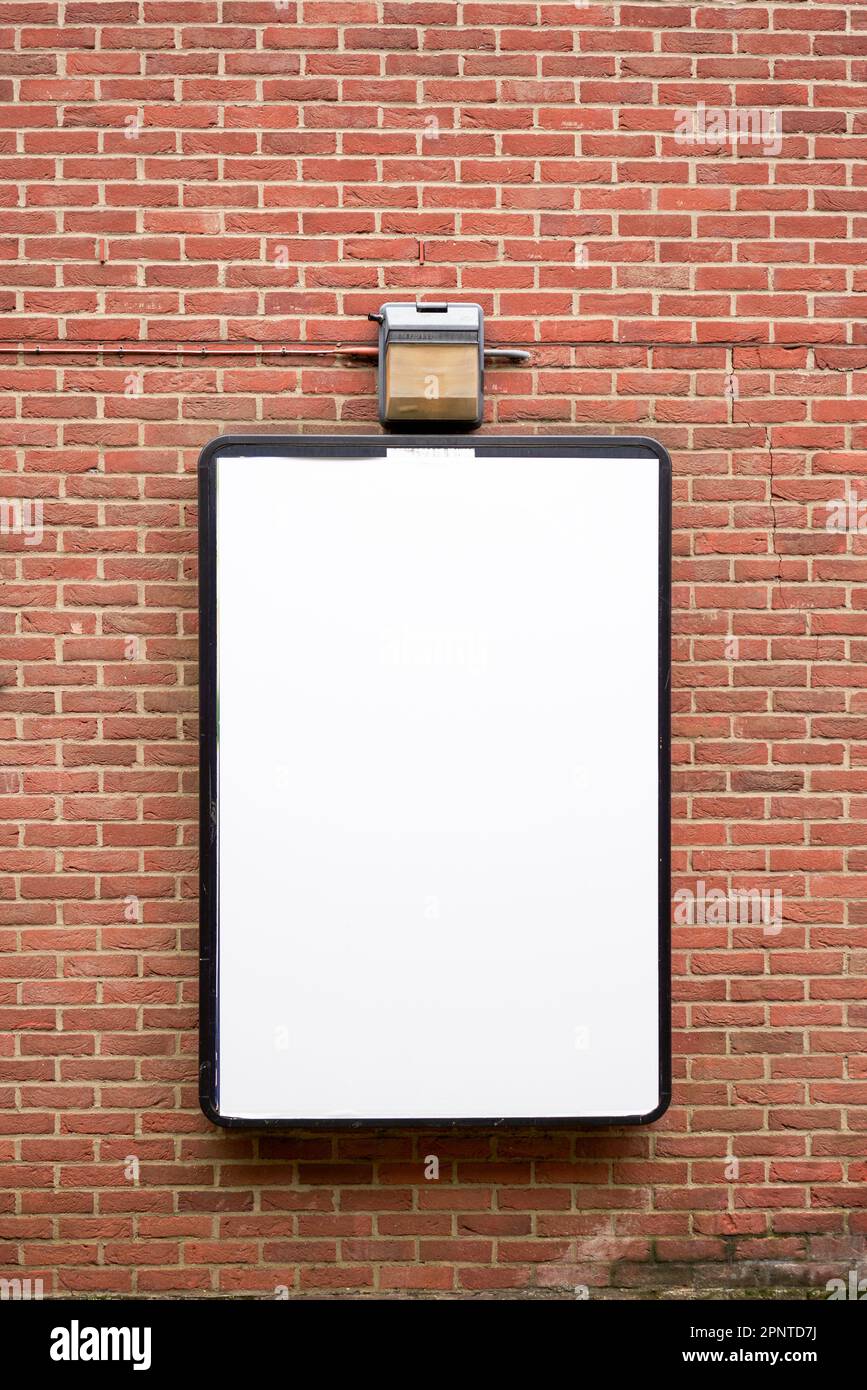 Bacheca vuota bianca sulla parete di mattoni rossi Foto Stock