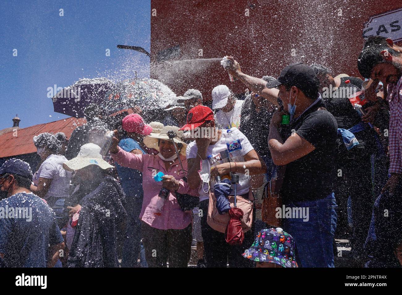 I celebratori della settimana Santa spruzzano schiuma l'uno sull'altro in Mineral del Chico, Hidalgo, Messico il 17 aprile 2022. Dopo due anni di eventi annullati a causa della pandemia del coronavirus, le folle si riunirono per le festività pasquali. (Aline Suárez del Real/Global Press Journal) Foto Stock