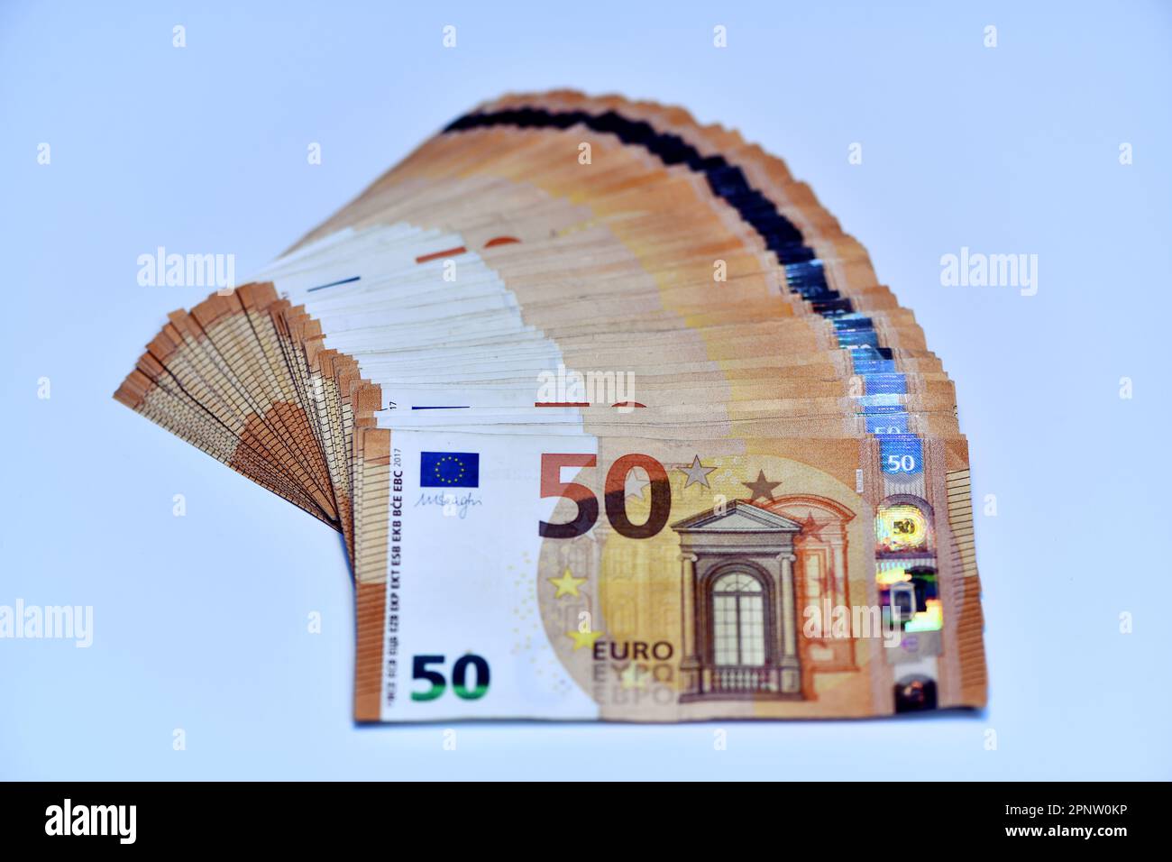 Concetto di molti euro: Un mucchio di banconote da 50 euro arrotolate su uno sfondo bianco per migliaia di euro in banconote da 50 euro Foto Stock