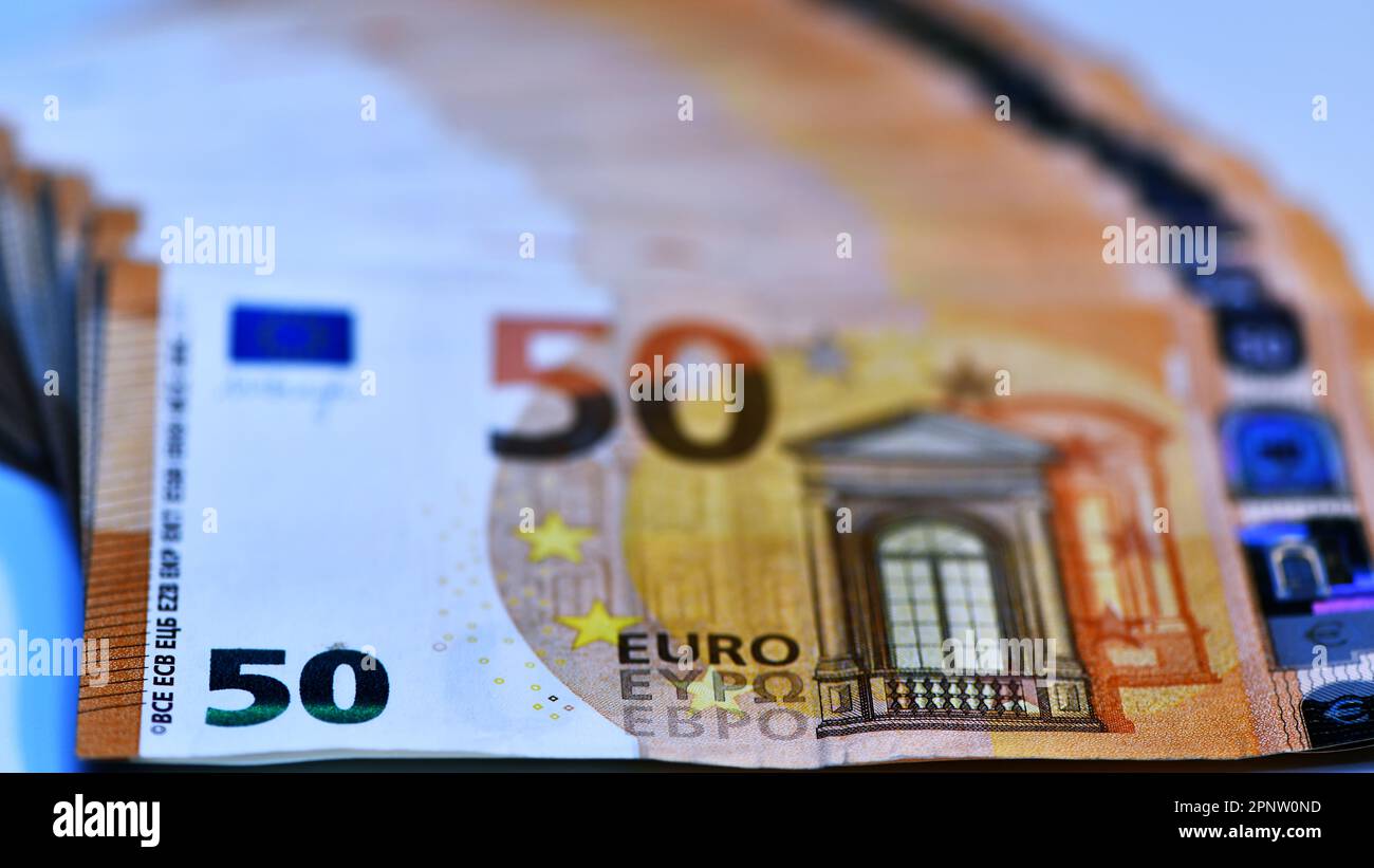 Concetto di molti euro: Un mucchio di banconote da 50 euro arrotolate su uno sfondo bianco per migliaia di euro in banconote da 50 euro Foto Stock