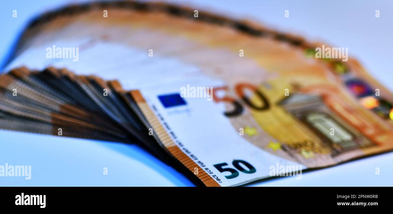 Concetto di molti euro: Un mucchio di banconote da 50 euro arrotolate su uno sfondo bianco per migliaia di euro in banconote da 50 euro Foto Stock
