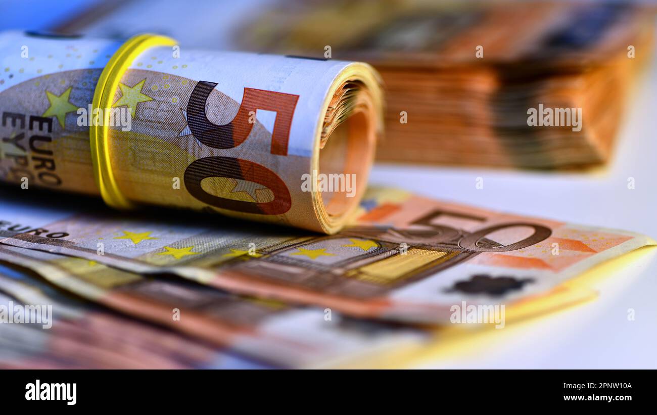 Concetto di molti euro: Un mucchio di banconote da 50 euro arrotolate su uno sfondo bianco per migliaia di euro in banconote da 50 euro Foto Stock
