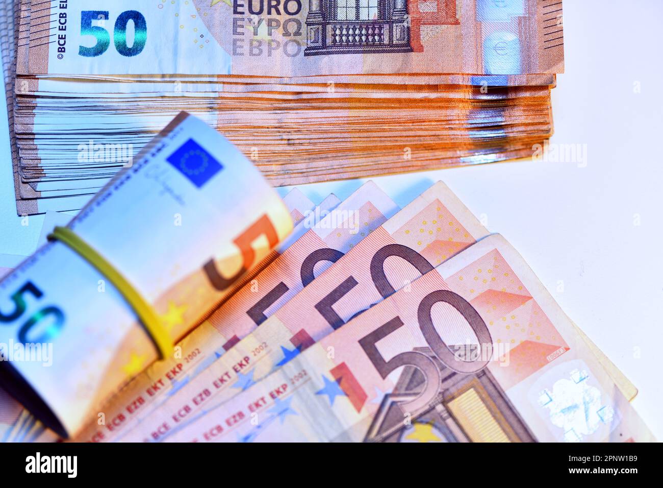 Concetto di molti euro: Un mucchio di banconote da 50 euro arrotolate su uno sfondo bianco per migliaia di euro in banconote da 50 euro Foto Stock