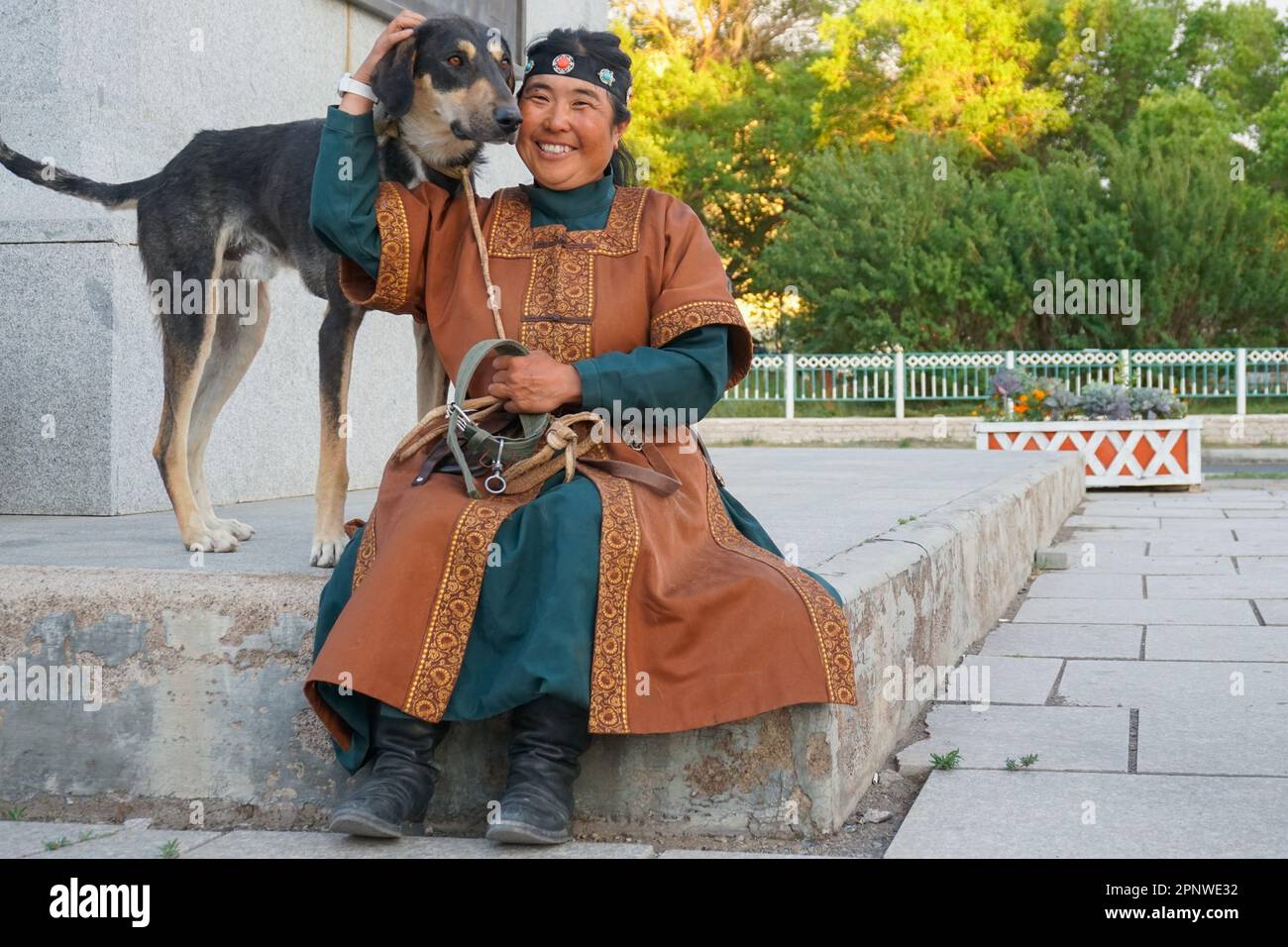 Chika Yamamoto sorride con il suo cane, Musa il vento di steppe, a Dalanzadgad, provincia di Umnugovi, Mongolia il 22 luglio 2022. Chika è un membro del Celestial Nomads, un progetto lanciato nel febbraio 2022 per promuovere il patrimonio culturale della Mongolia viaggiando intorno al paese con i cani taiga e cavalli. (Uranchimeg Tsoghuu/Global Press Journal) Foto Stock