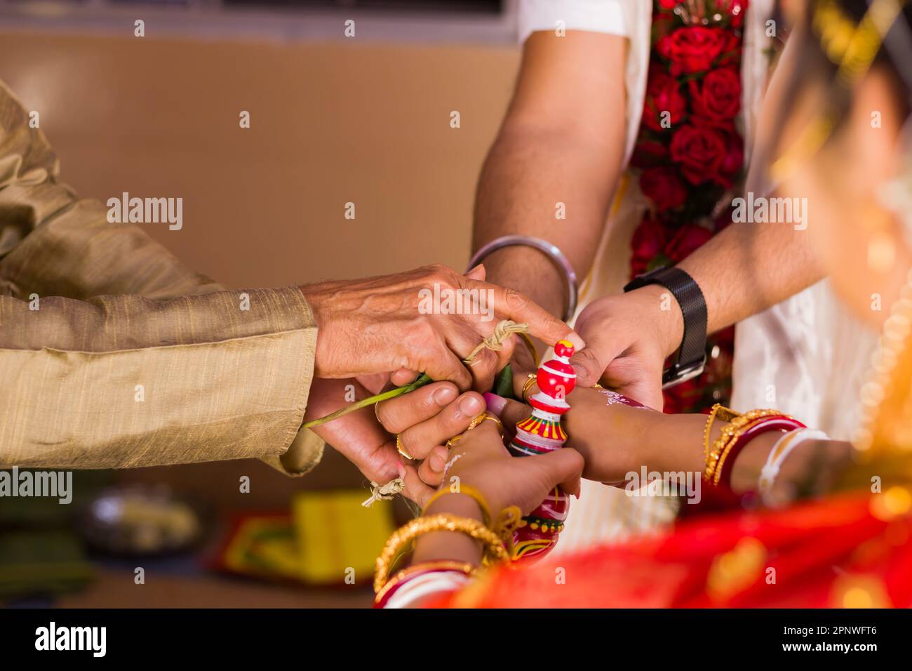 Rituale di matrimonio indù durante il matrimonio, dove gli anziani di famiglia sigilla il legame tra sposa e sposo tenendoli a portata di mano. Questo rito è chiamato s. Foto Stock