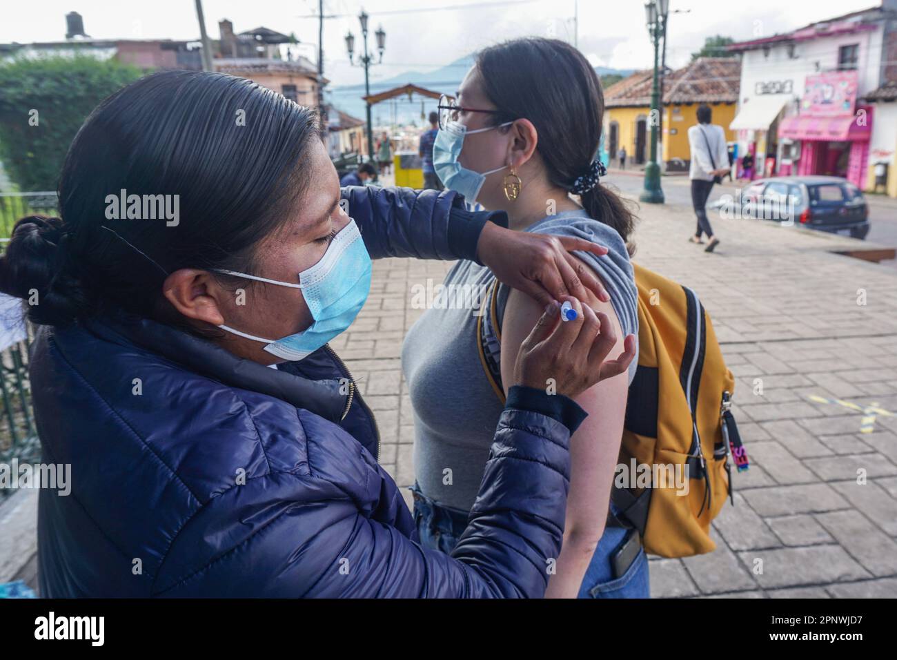 Juana Méndez dà a Patricia Maza un colpo d'influenza in un'unità di vaccinazione mobile a San Cristóbal de Las Casas, Chiapas, Messico il 12 novembre 2021. “Vengo ogni anno per ottenere il vaccino antinfluenzale e da quando è iniziata la pandemia COVID-19, ho pensato che fosse essenziale per me venire a prendere il vaccino”, afferma Maza. "Immagina ora con il freddo. Non posso ammalarmi con l'influenza e COVID-19. Sarebbe una situazione molto rischiosa”. (Adriana Alcázar González/Global Press Journal) Foto Stock