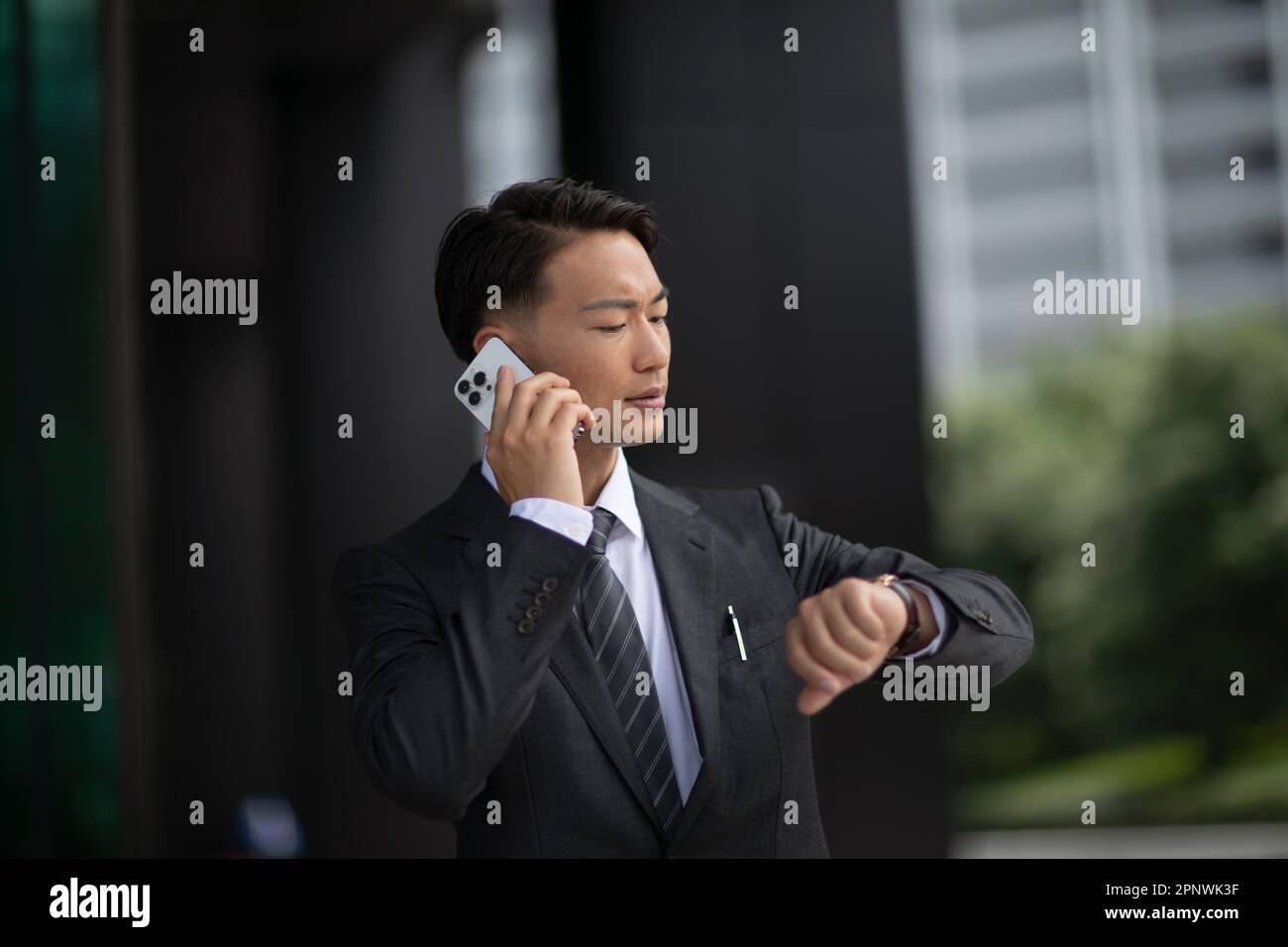Imprenditore guardando il suo orologio Foto Stock