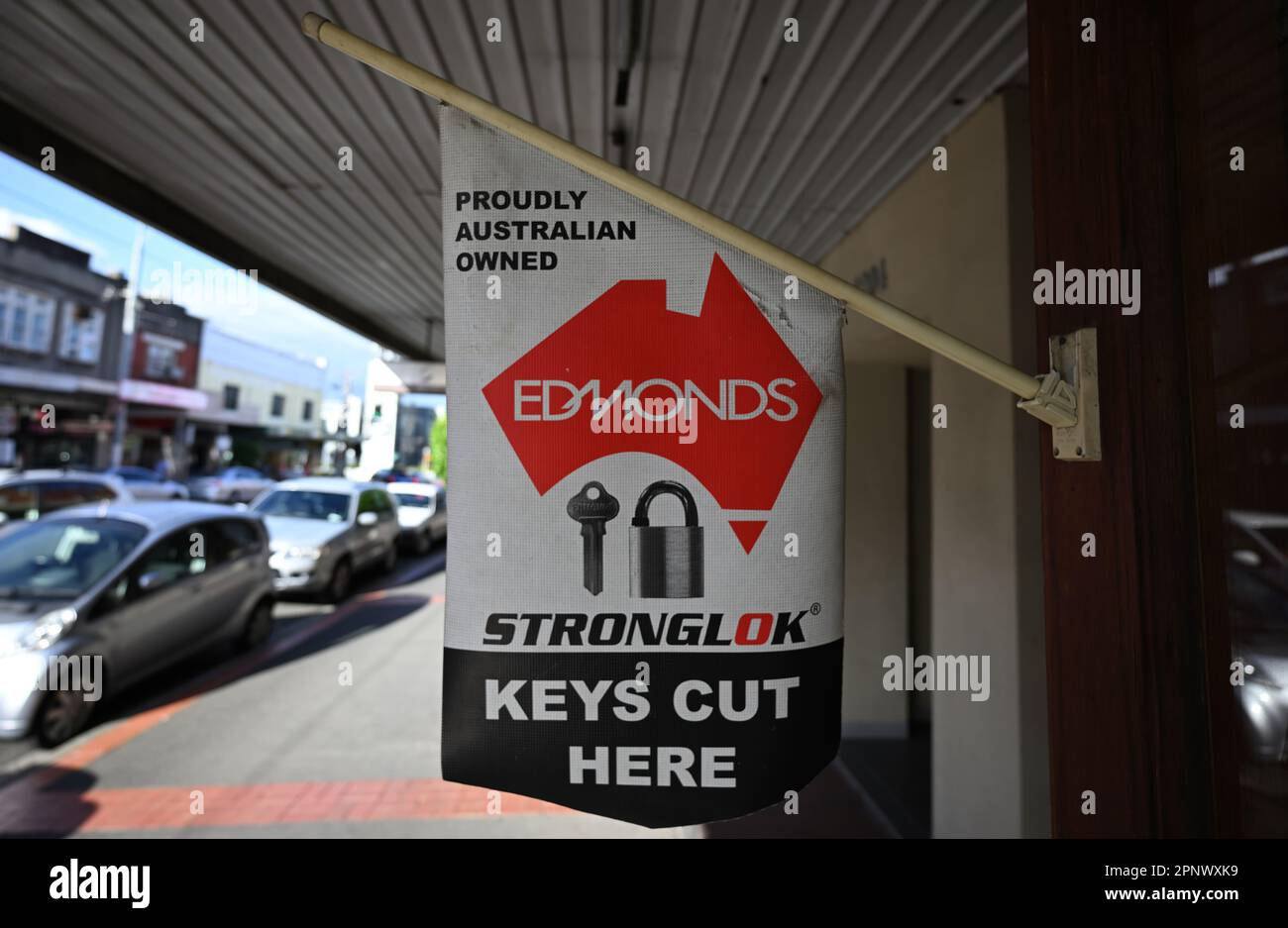 Bianco, rosso e nero Edmonds Stronglok key cutter segno fuori di un negozio, con il segno che sottolinea che l'azienda è di proprietà australiana Foto Stock