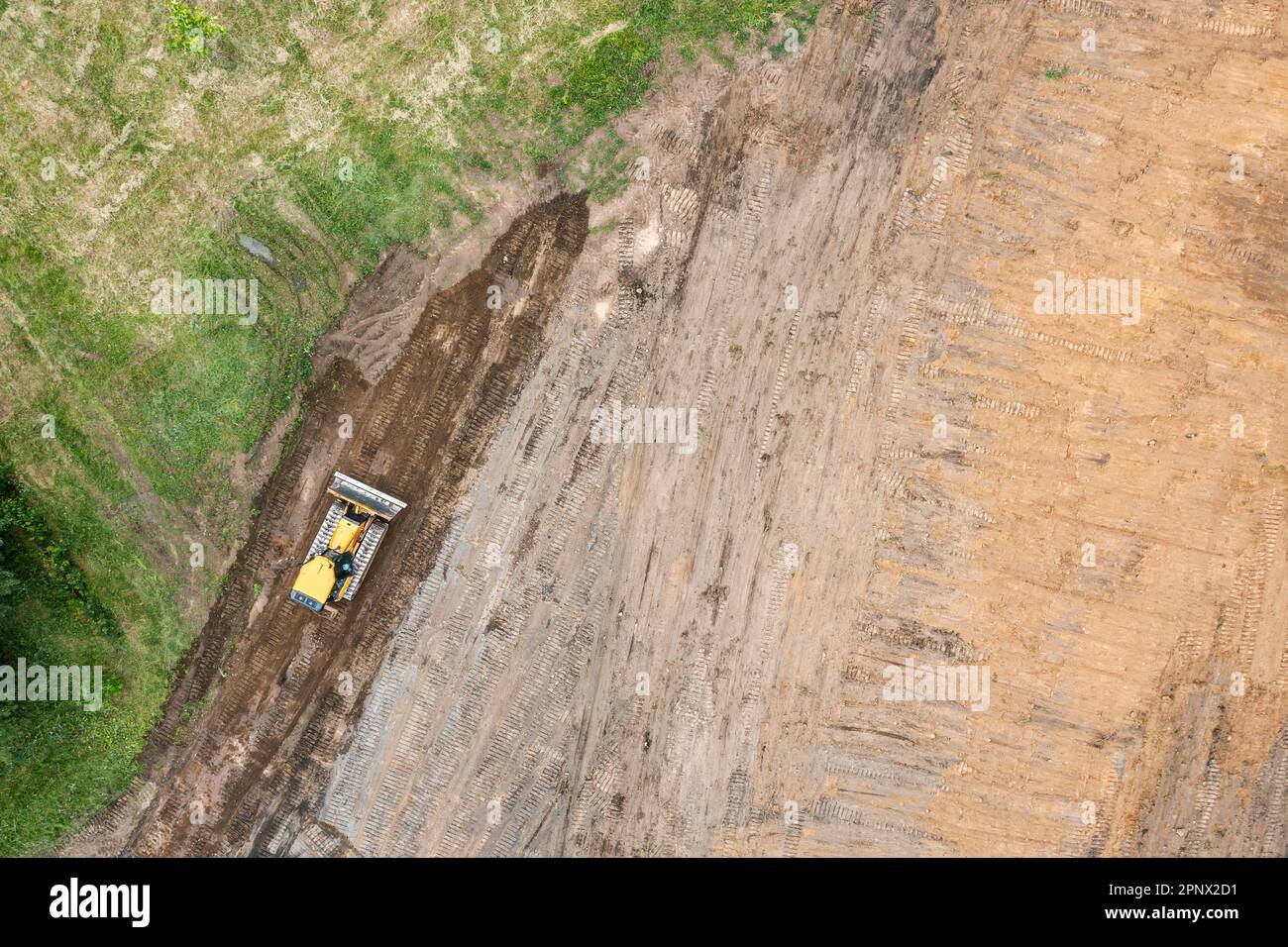 il bulldozer giallo esegue lavori di scavo in cantiere. vista degli uccelli. Foto Stock