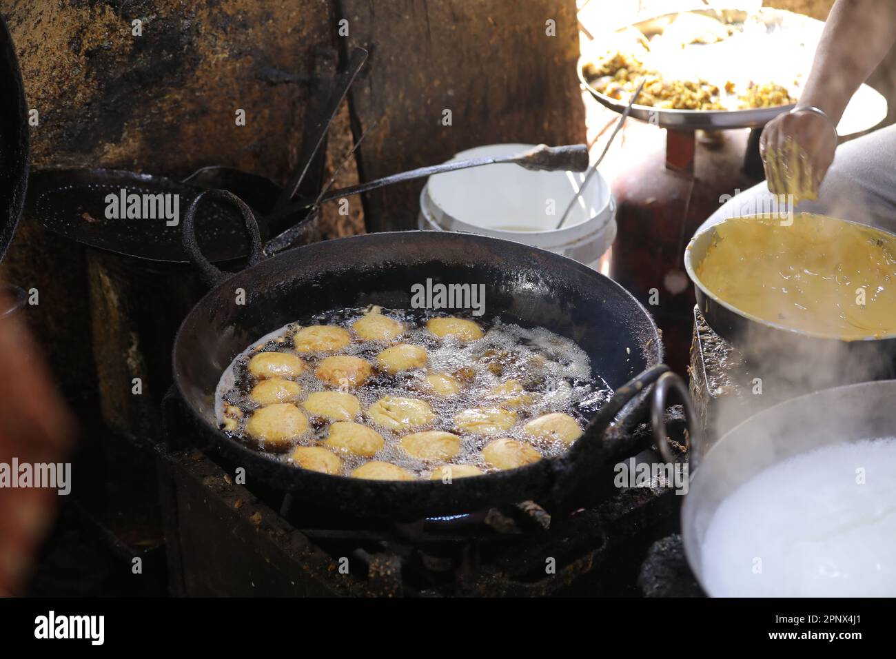 Friggere i kachori in una padella in una bancarella di cibo di strada, cibo oleoso Foto Stock