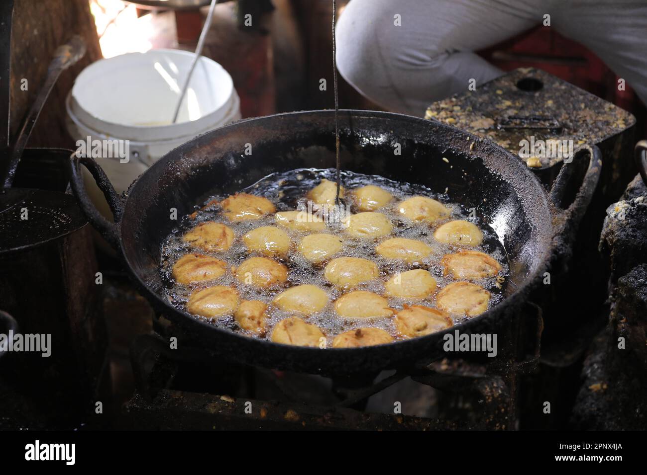 Friggere i kachori in una padella in una bancarella di cibo di strada, cibo oleoso Foto Stock