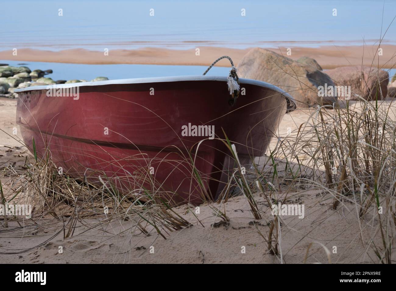 Solitaria barca da pesca rossa sulla spiaggia Foto Stock