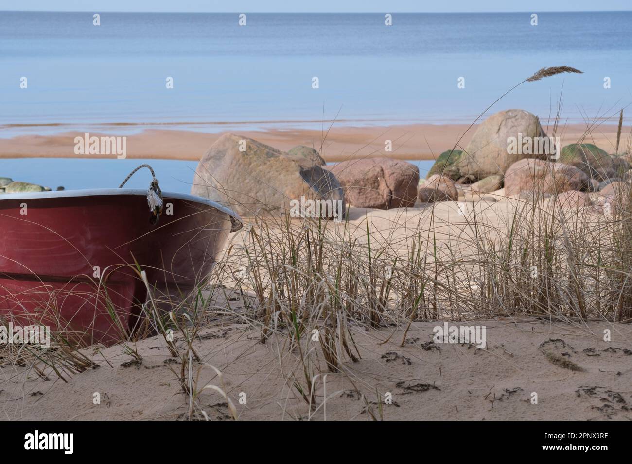 Solitaria barca da pesca rossa sulla spiaggia Foto Stock
