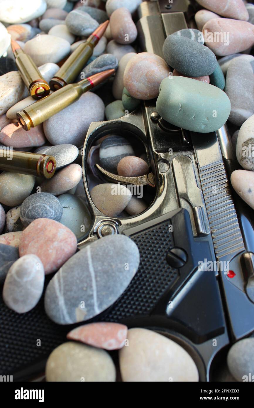 Scena del crimine con una pistola coperta di pietre di mare e munizioni sparse Foto Stock