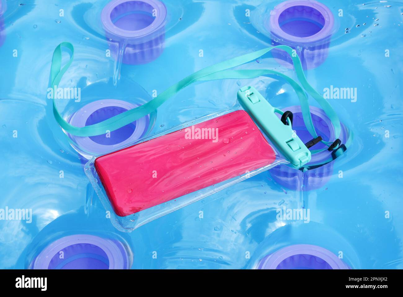 Copertura protettiva in plastica trasparente impermeabile per un telefono cellulare o un cellulare su un materasso gonfiabile da piscina Foto Stock