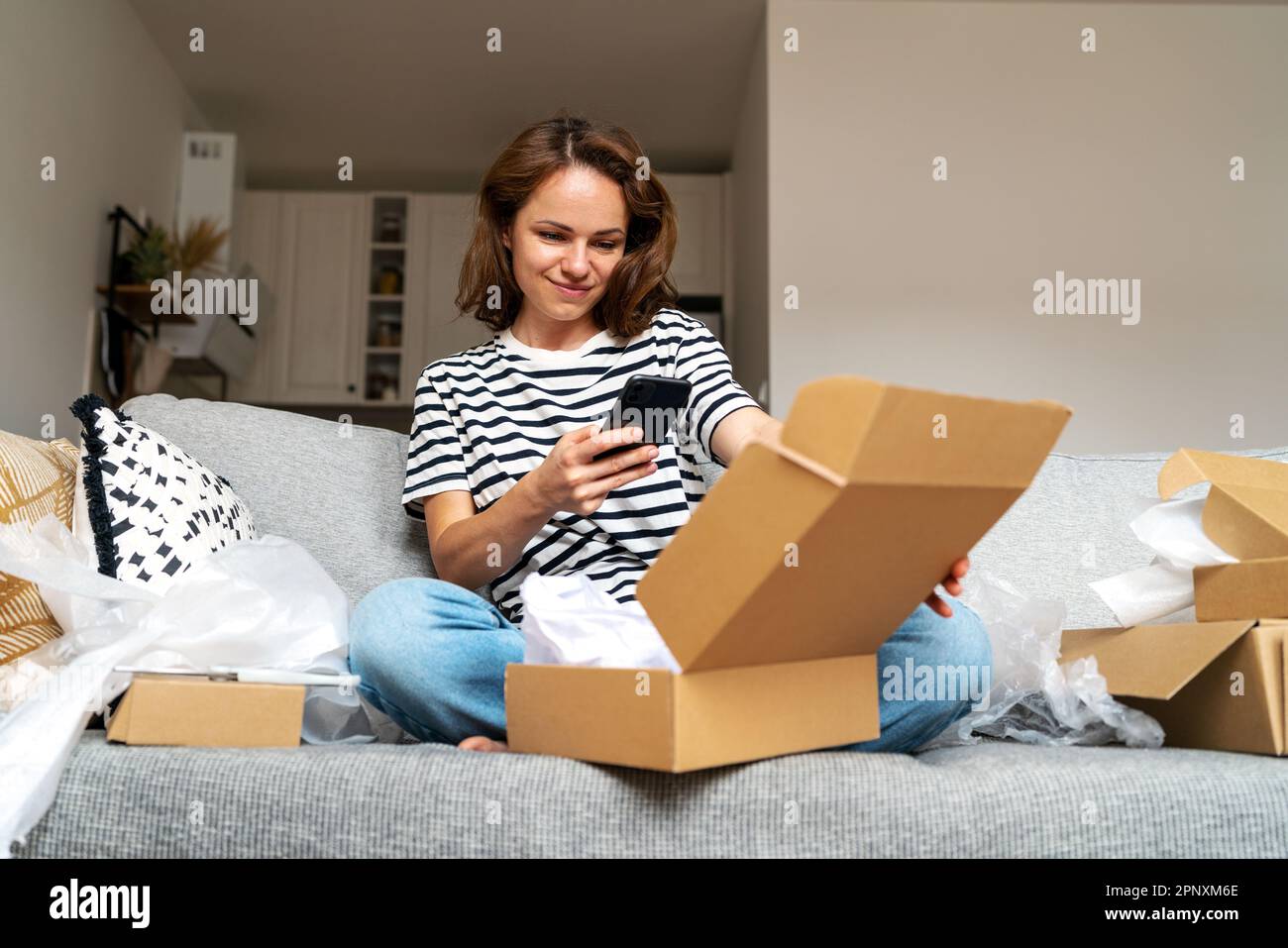 Giovane donna che condivide il tuo feedback e i tuoi commenti sul servizio di consegna e sul negozio online. Foto Stock