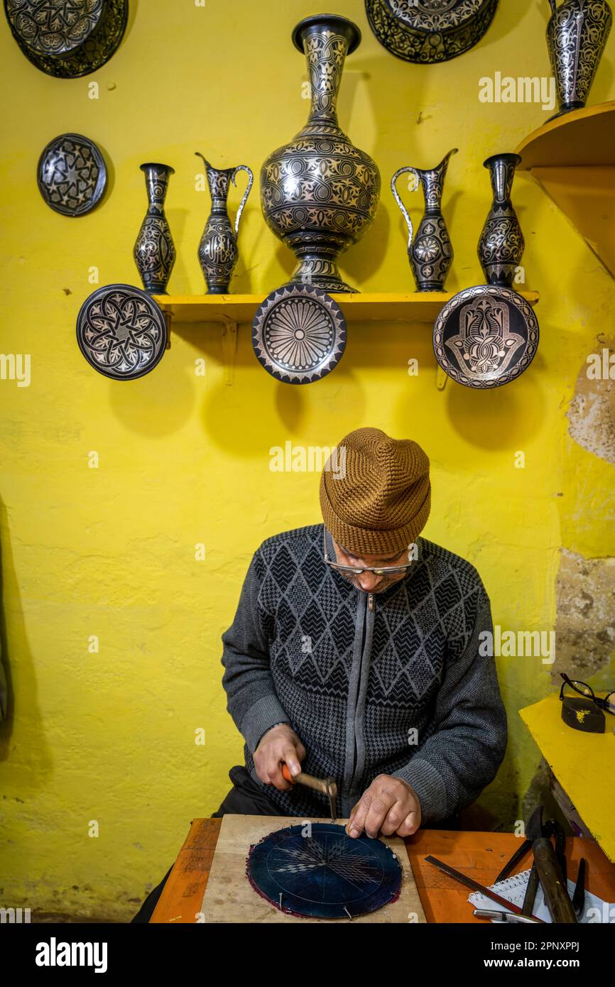 Artigiano che decora un piatto con la tecnica damascena. Foto Stock