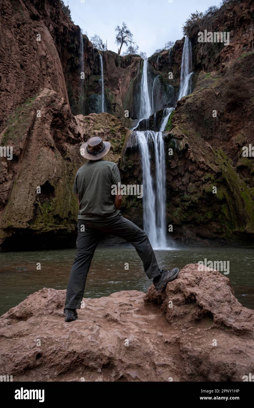 Uomo con cappello di pelle che guarda le cascate di Ouzoud. Foto Stock