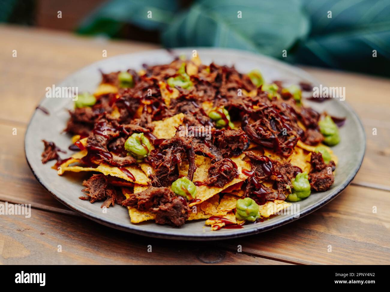 Nachos messicani con manzo e peperoncino su tavola di legno Foto Stock