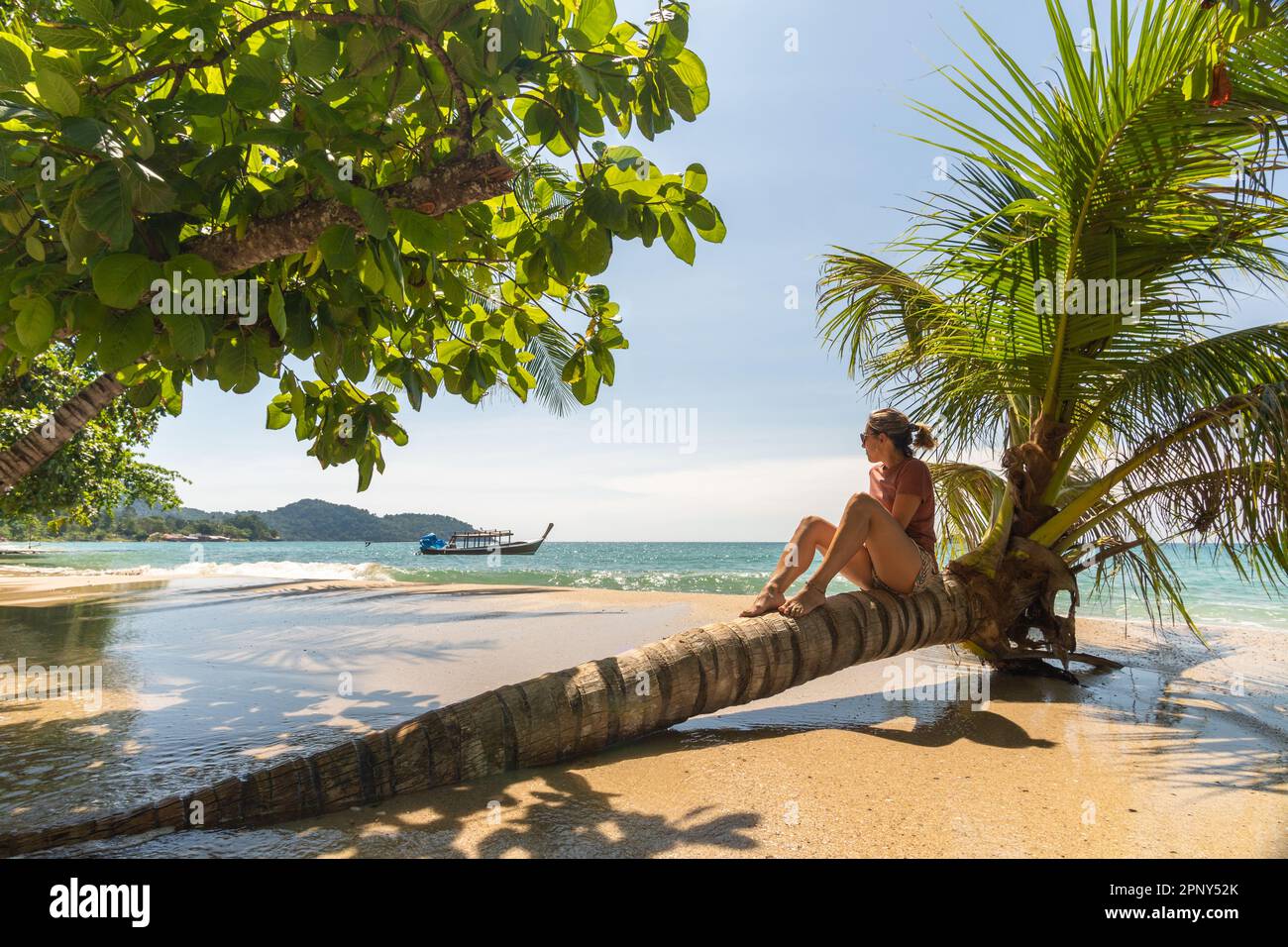 Donna viaggiatore seduta su palma godendo la spiaggia e il mare Foto Stock