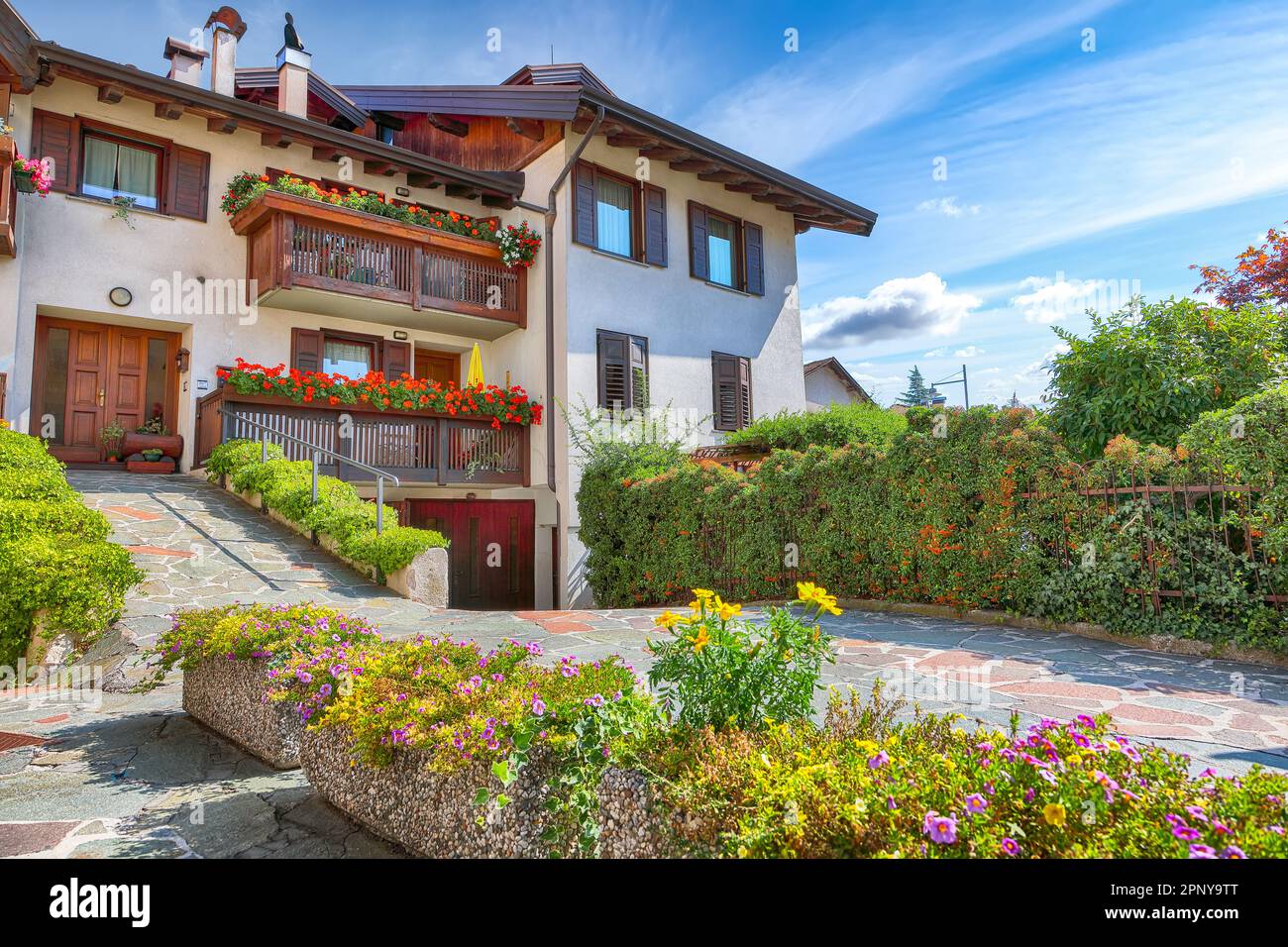 Splendida vista delle case alpine tradizionali con fiori sul balcone della città di Cles. Ubicazione: Cles, Trentino-Alto Adige, Italia, Europa Foto Stock