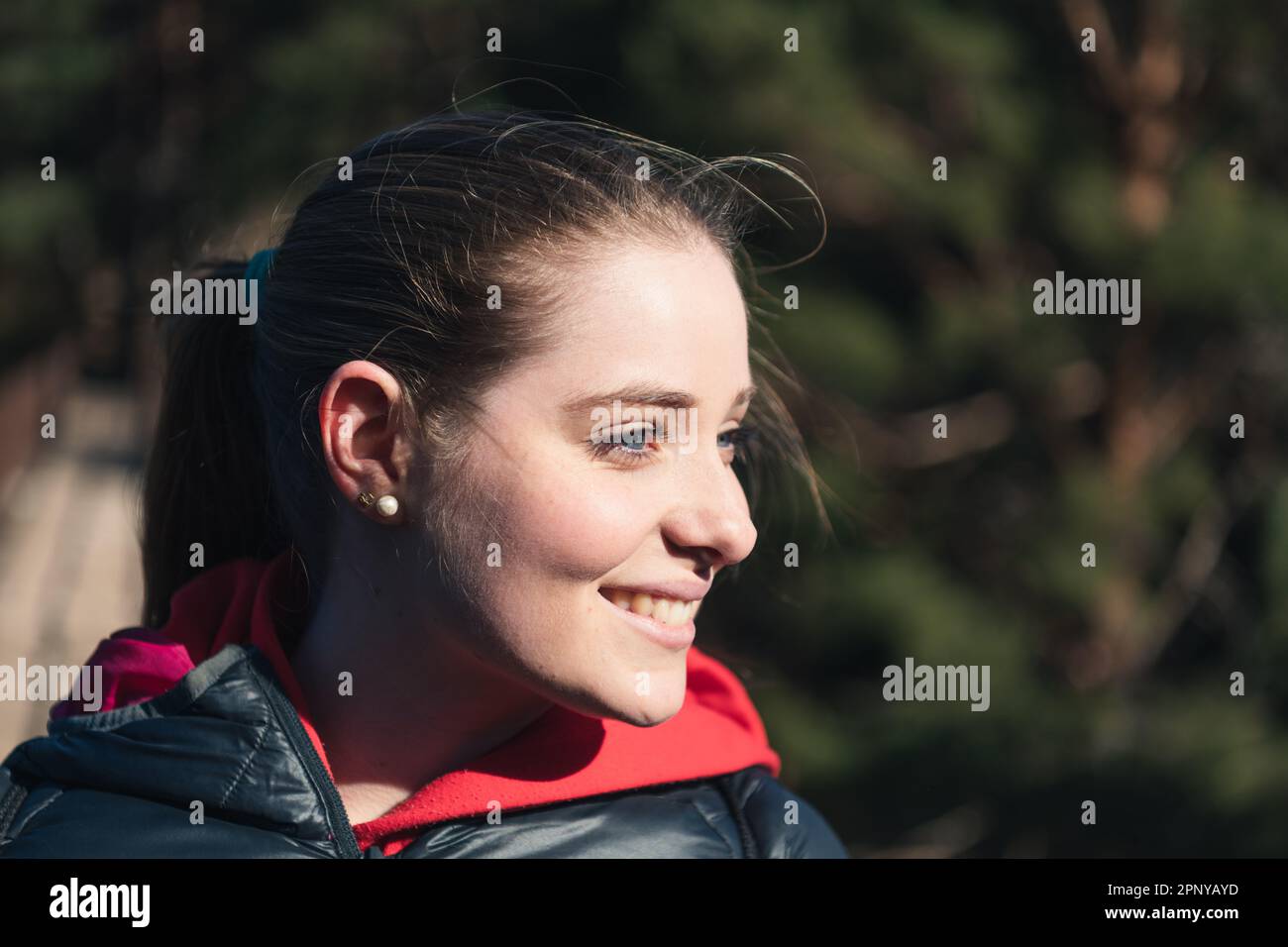 Ritratto di una giovane donna dall'occhio blu sorridente nella natura Foto Stock
