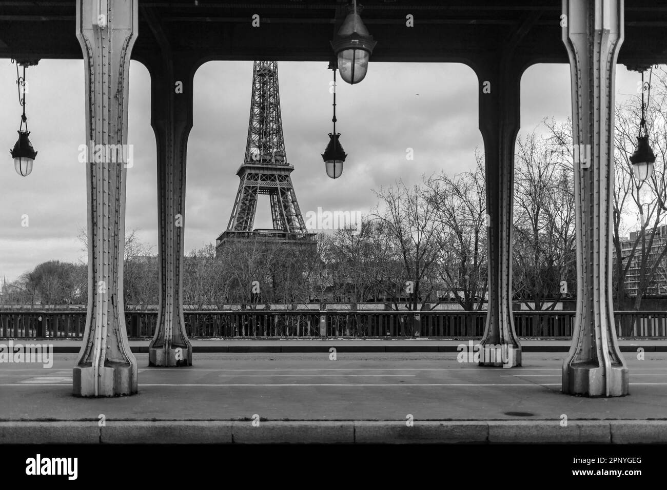 Una foto in scala di grigi del ponte di Bir-Hakeim con colonne e la Torre Eiffel sullo sfondo, Parigi, Francia. Foto Stock