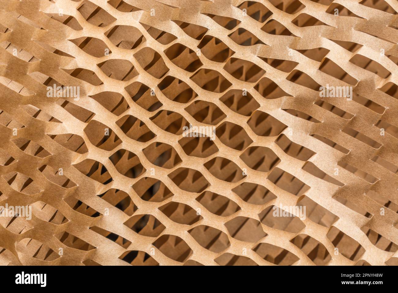 Grande foto ravvicinata di carta riempitrice a nido d'ape frantumata utilizzata nei processi di movimentazione dei materiali per la spedizione di merci o prodotti delicati. Foto Stock