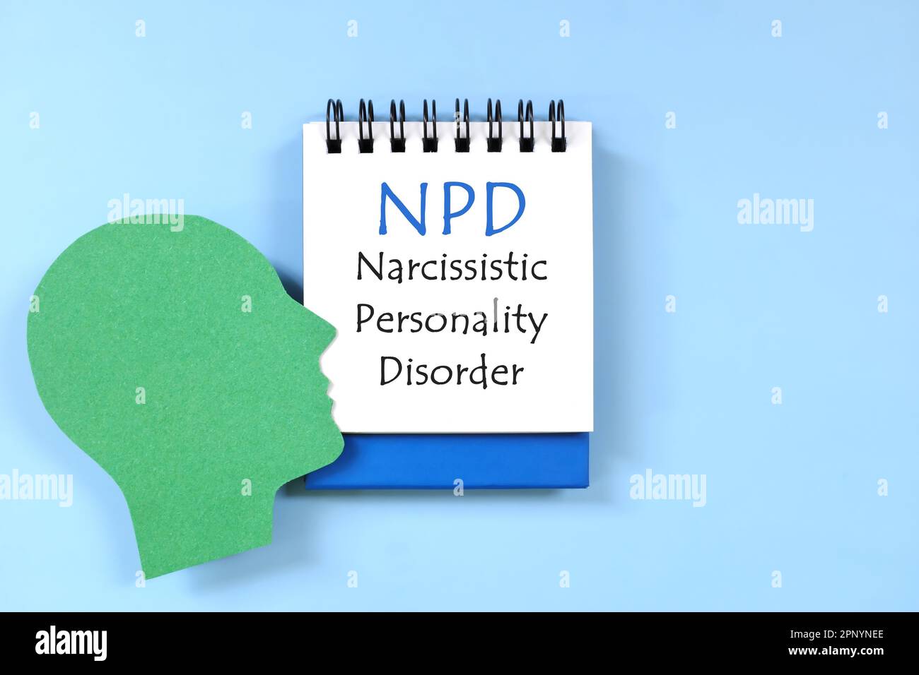 Disturbo di personalità narcisistico o diagnosi di NPD scritta su blocco note su sfondo blu. Composizione di posa piatta. Foto Stock