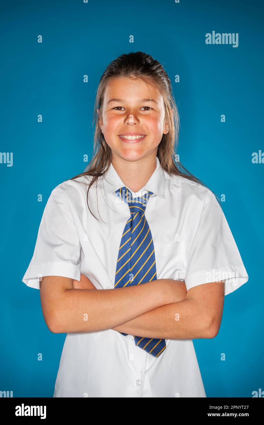 I bambini sorridono in uniforme scolastica su uno sfondo semplice Foto Stock