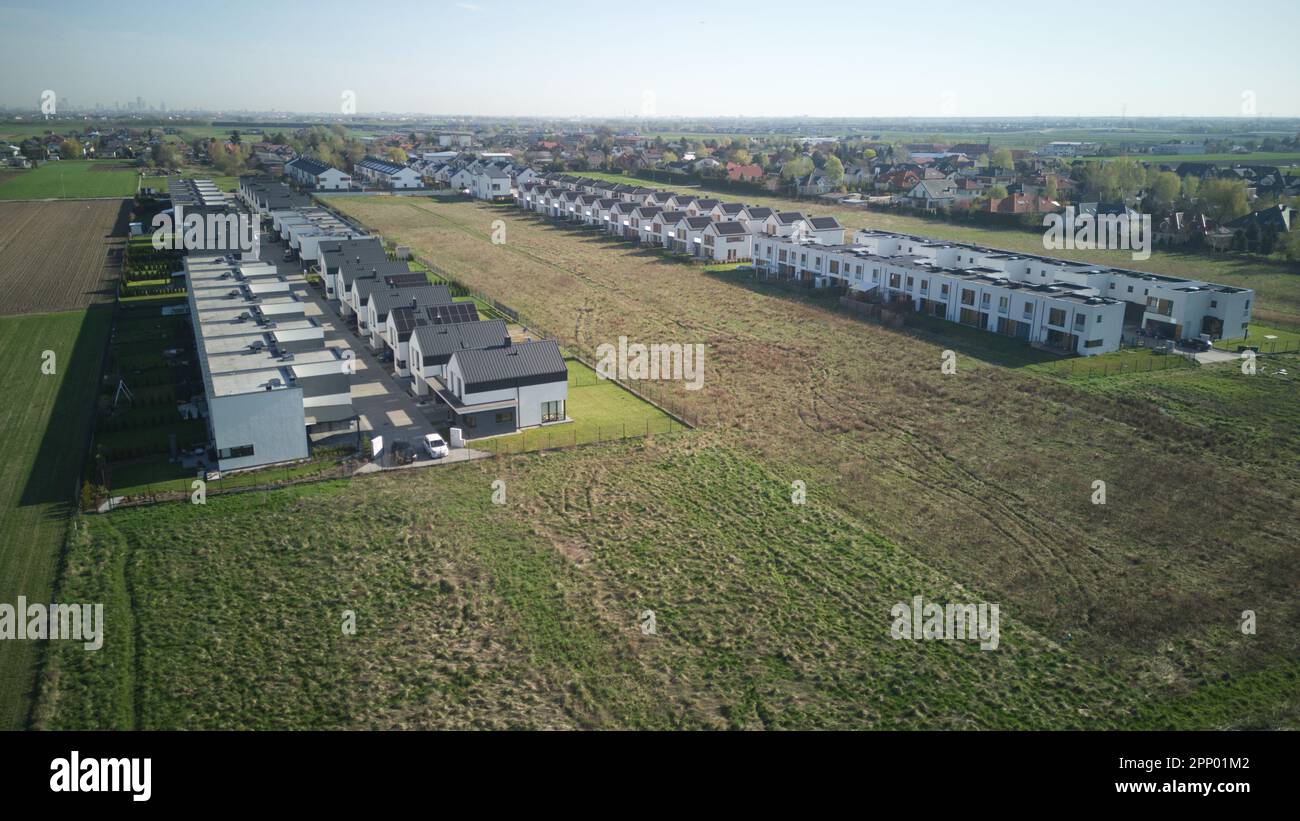 Veduta aerea della sorgente di caldo sole case comunità quartiere con una sola strada e campo intorno. Foto Stock