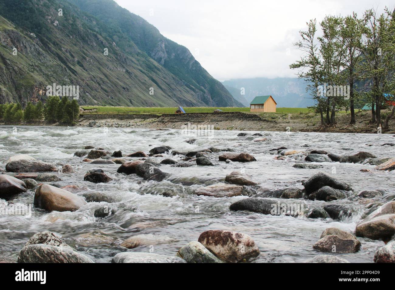 Casa sulle rive del fiume veloce Chulyshman, nelle montagne Altai. Pietre in acqua, alberi verdi. Centro ricreativo turistico. Alta qualità pho Foto Stock