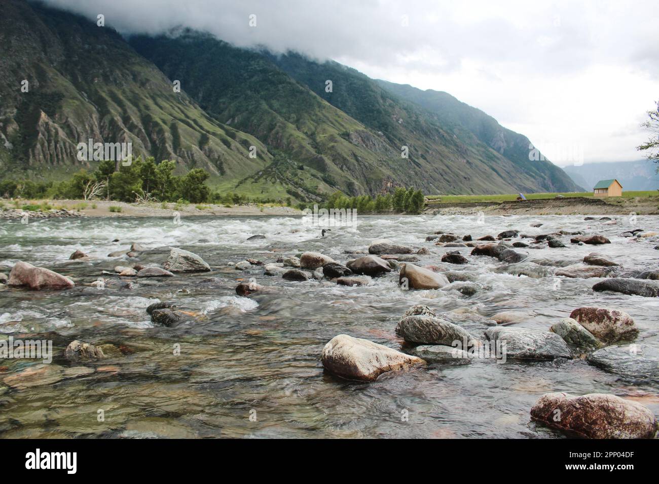 Casa sulle rive del fiume veloce Chulyshman, nelle montagne Altai. Pietre in acqua, alberi verdi. Centro ricreativo turistico. Alta qualità pho Foto Stock