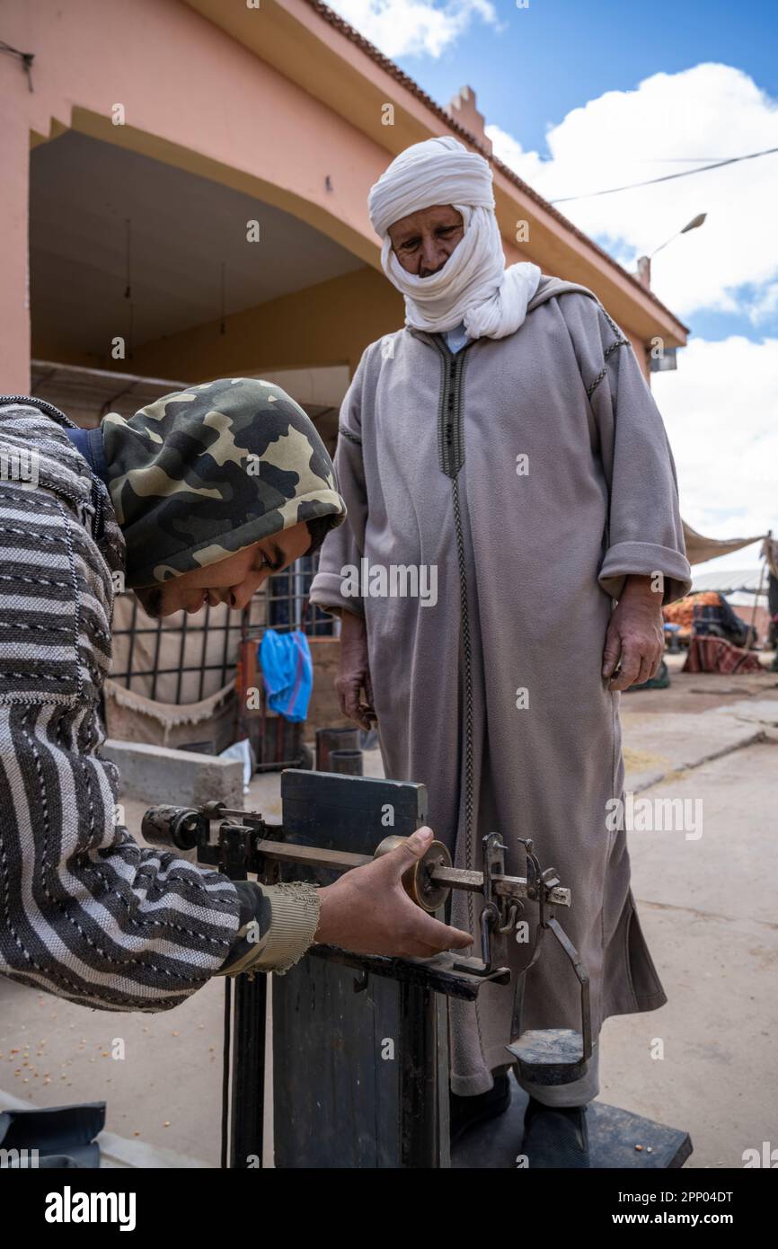 Uomo che si pesa su una scala nel mercato di Guelmim. Foto Stock