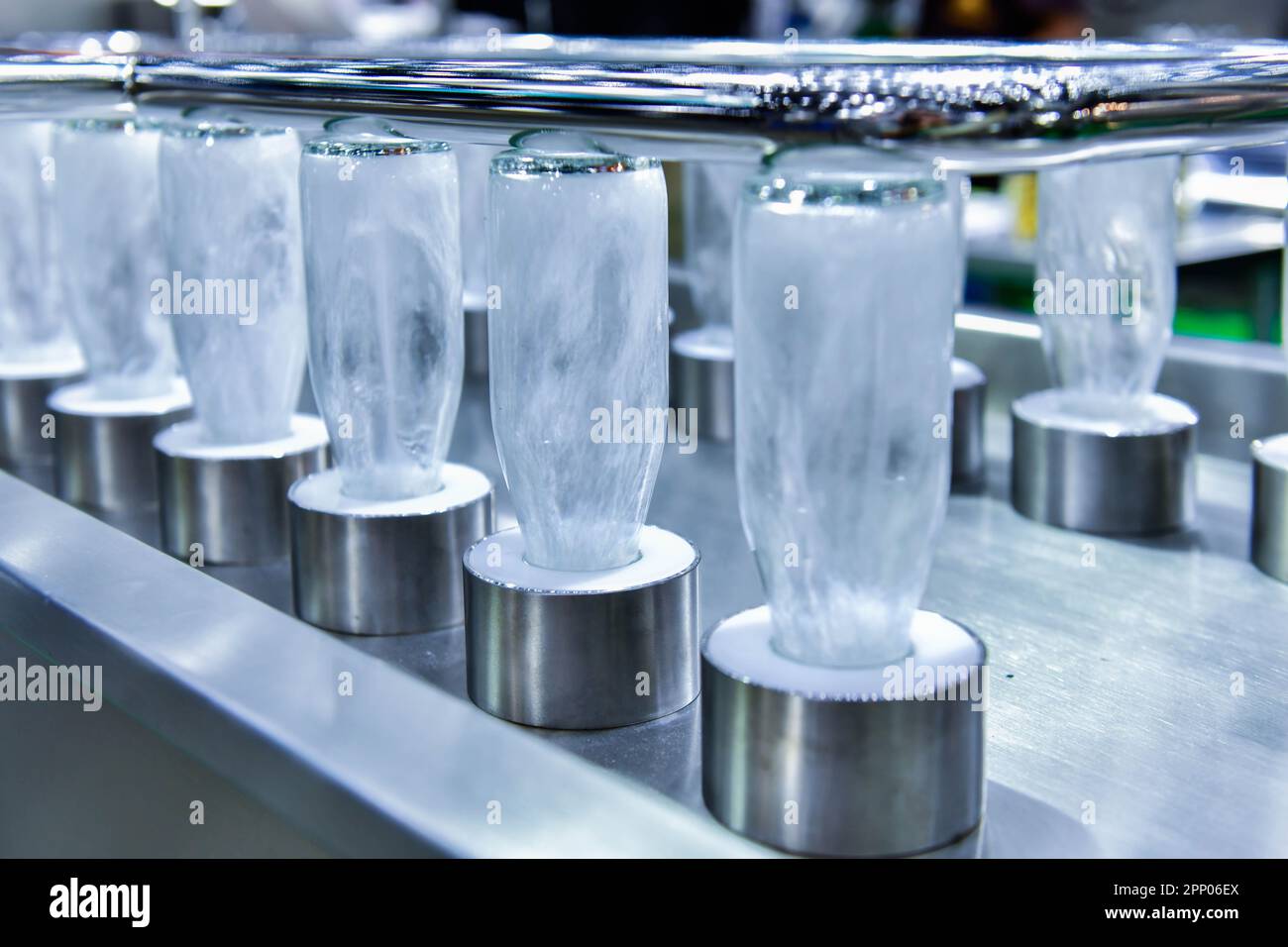 Bottiglie di pulizia bottiglie di vetro per prodotti di bevande in lavorazione acqua calda nella macchina automatica in fase di produzione Foto Stock