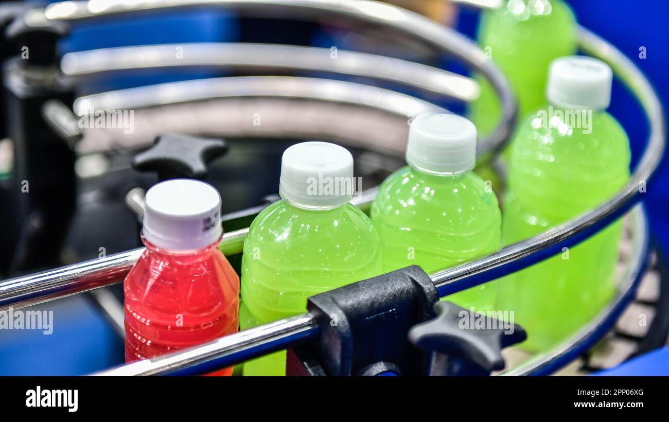 Le bottiglie di succo in plastica trasferiscono su sistemi trasportatori automatizzati automazione industriale per le confezioni Foto Stock