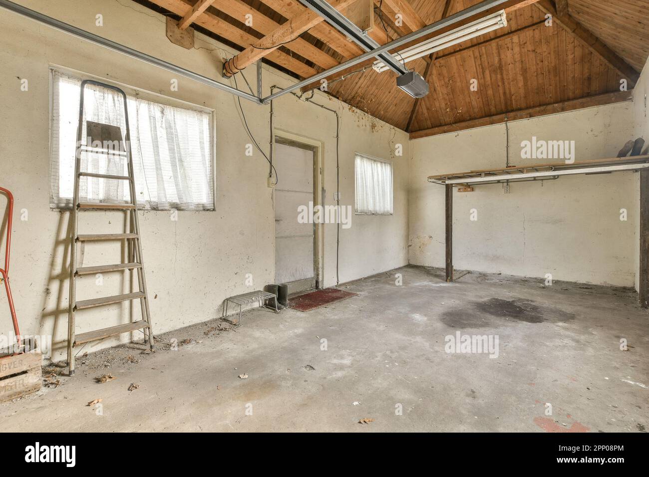 una stanza vuota senza nessuno sulla parete o sul soffitto e scale pendenti dal soffitto al pavimento Foto Stock