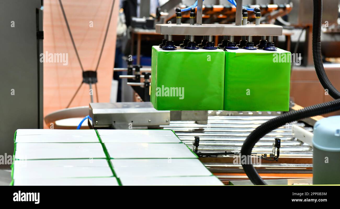 I bracci robotici industriali sono in dotazione per trasportare la scatola di cartone per la consegna in magazzino. Foto Stock