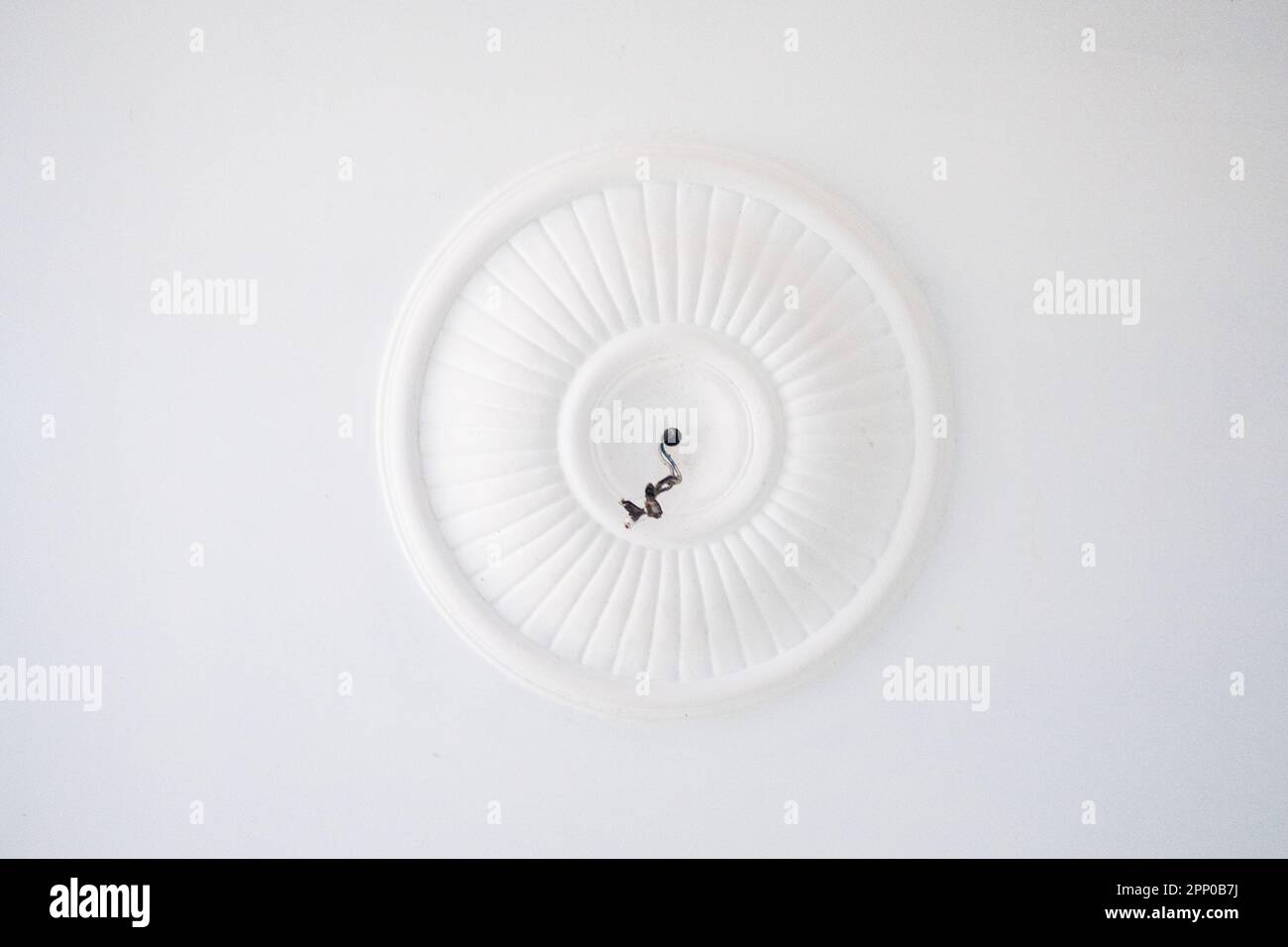 Un cerchio con un filo nero al centro al quale collegare il lampadario. Foto Stock
