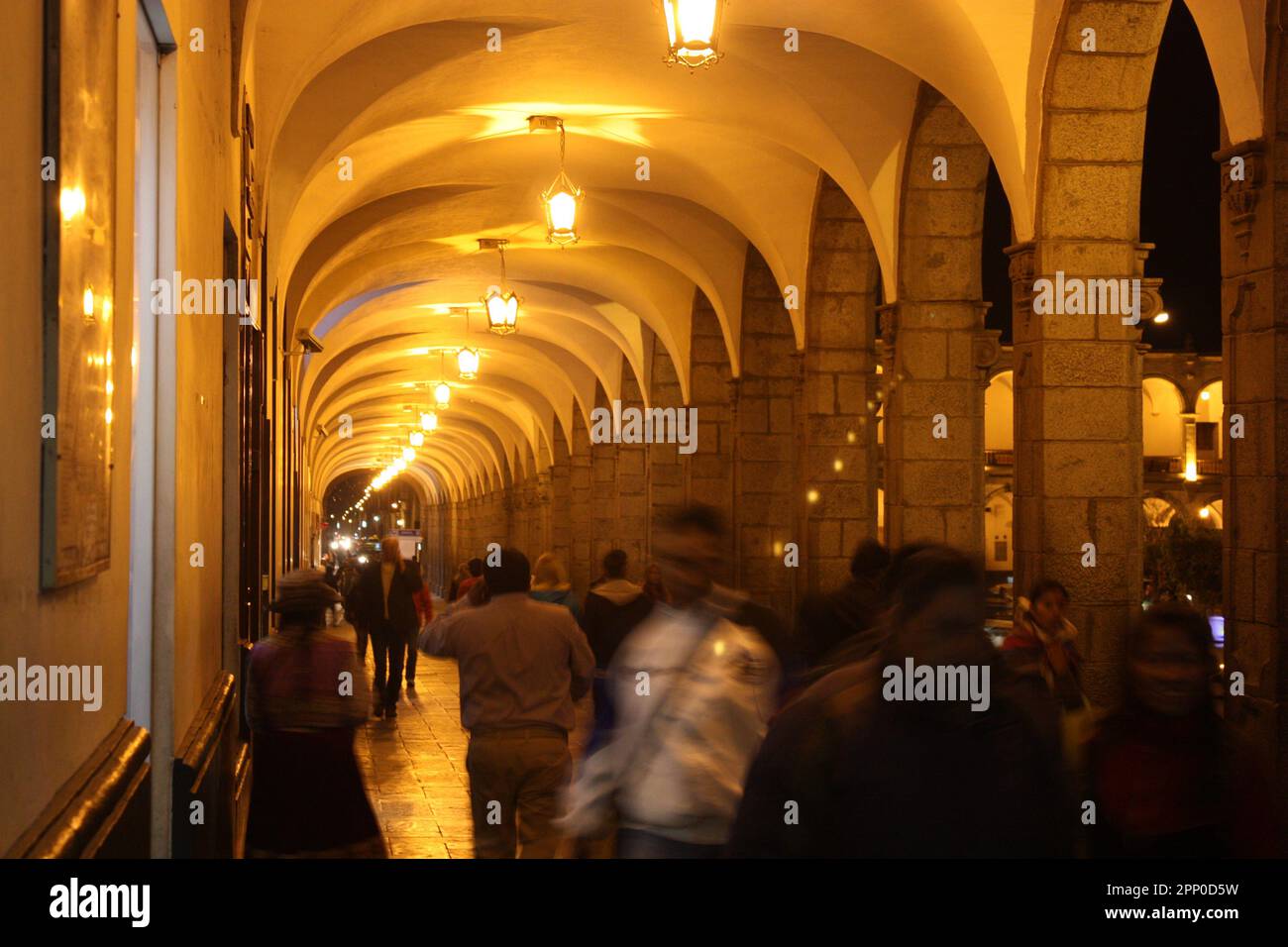 Passerella ad arco con persone sfocate di notte. Foto Stock